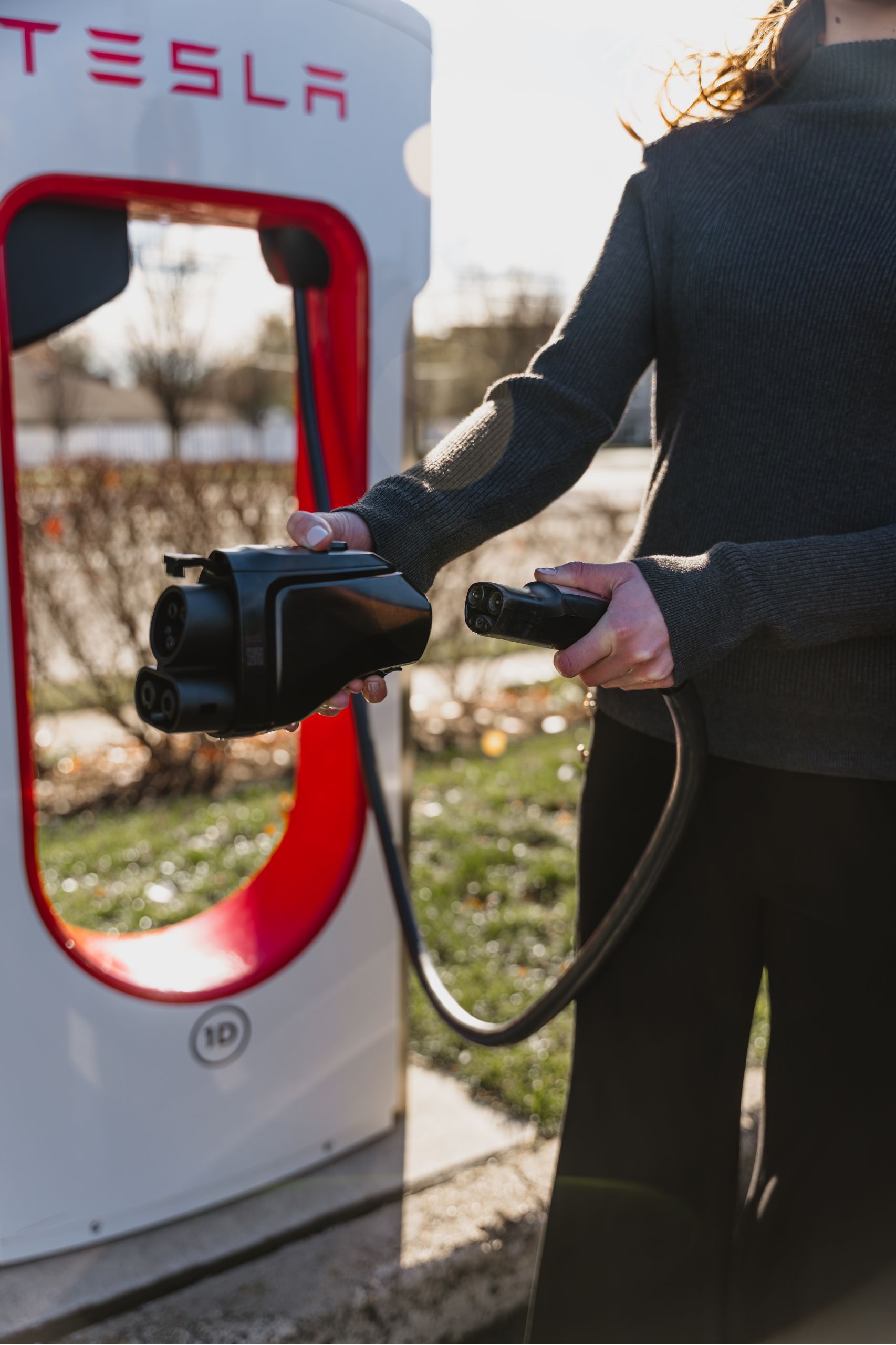 A driver connects the Lectron Vortex Plus DC adapter to a Tesla charger