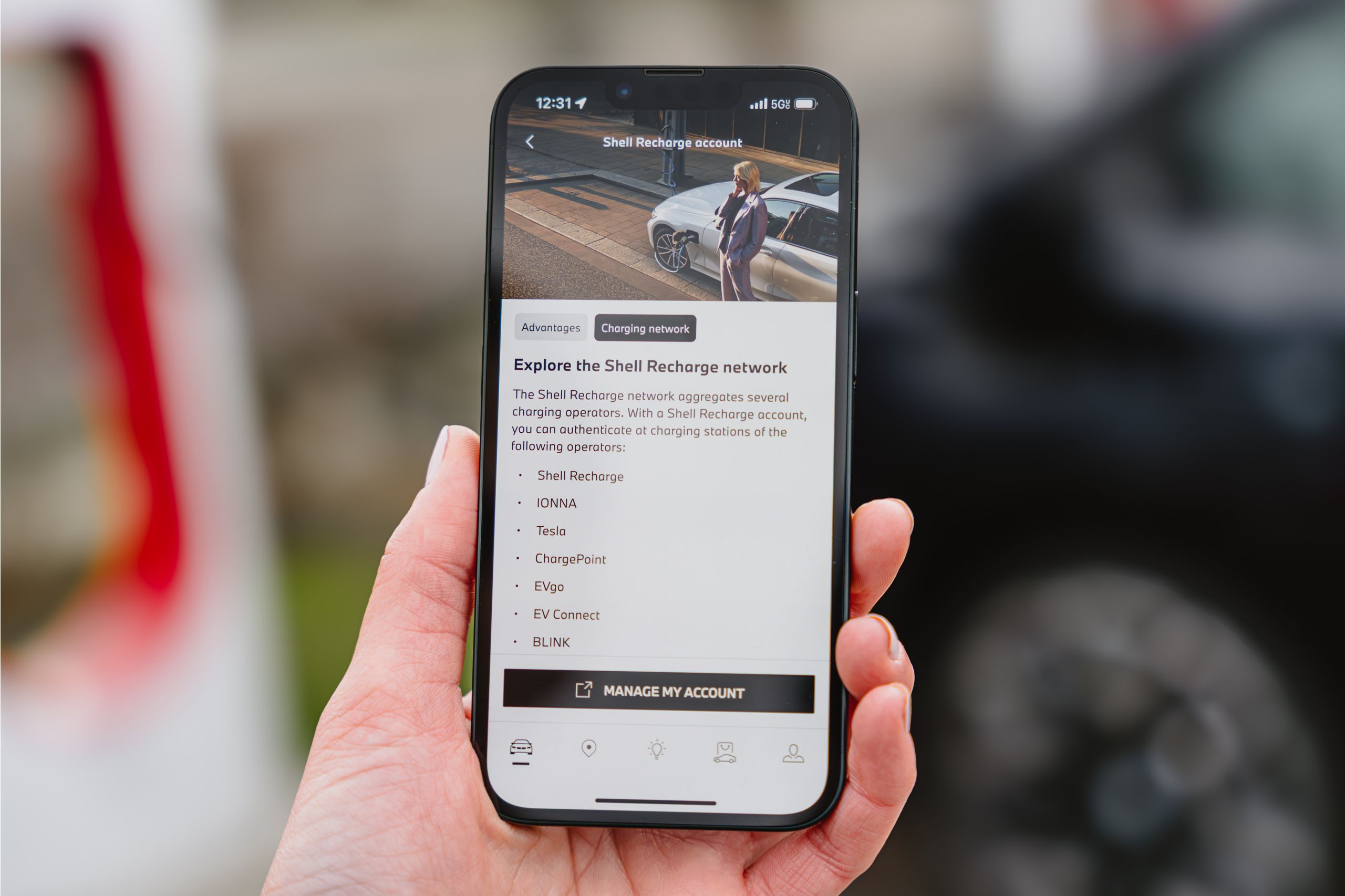 Close up of a hand holding a smartphone displaying a Shell Recharge account page