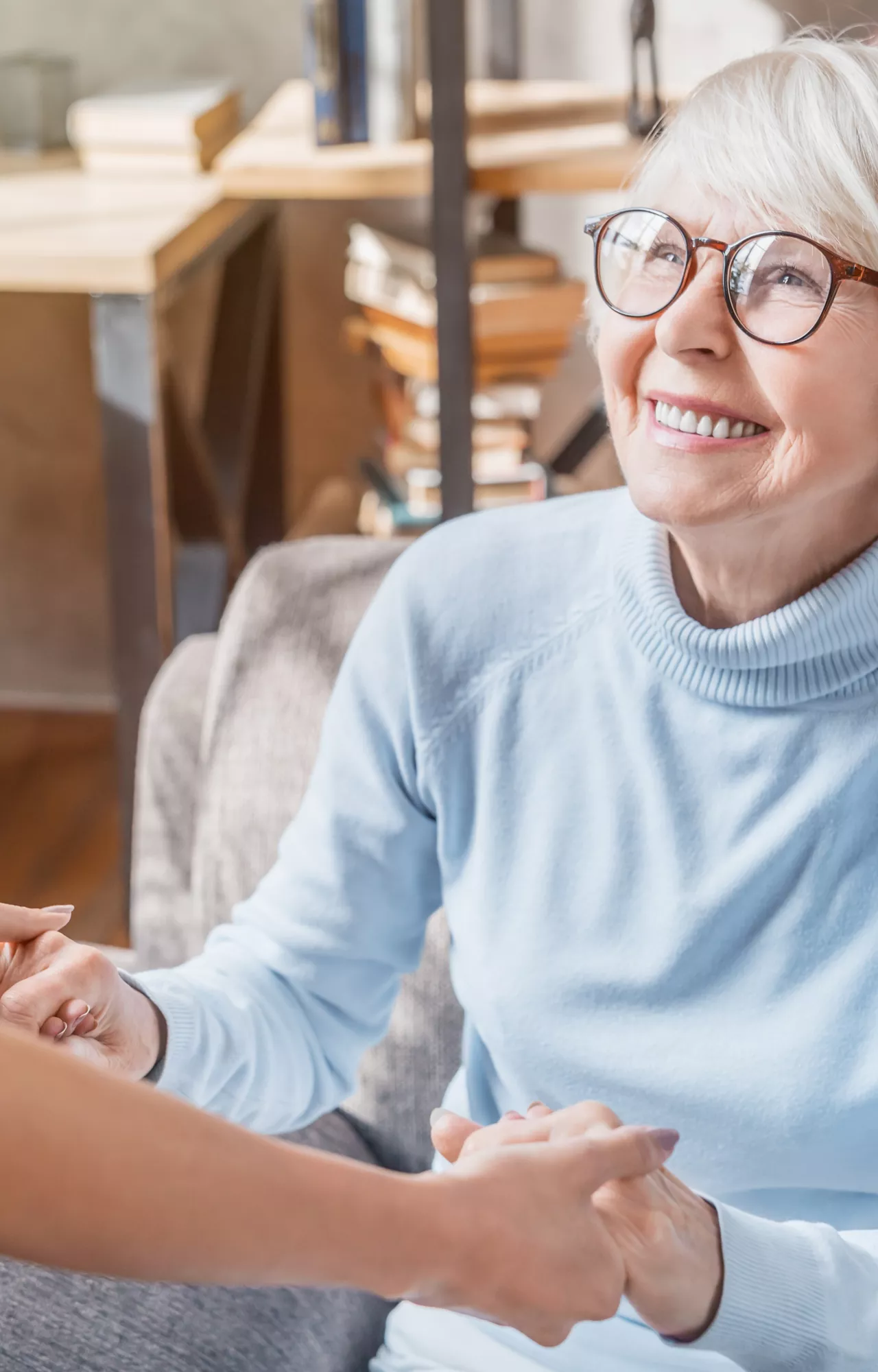 Ältere Dame hält die Hand einer Pflegerin