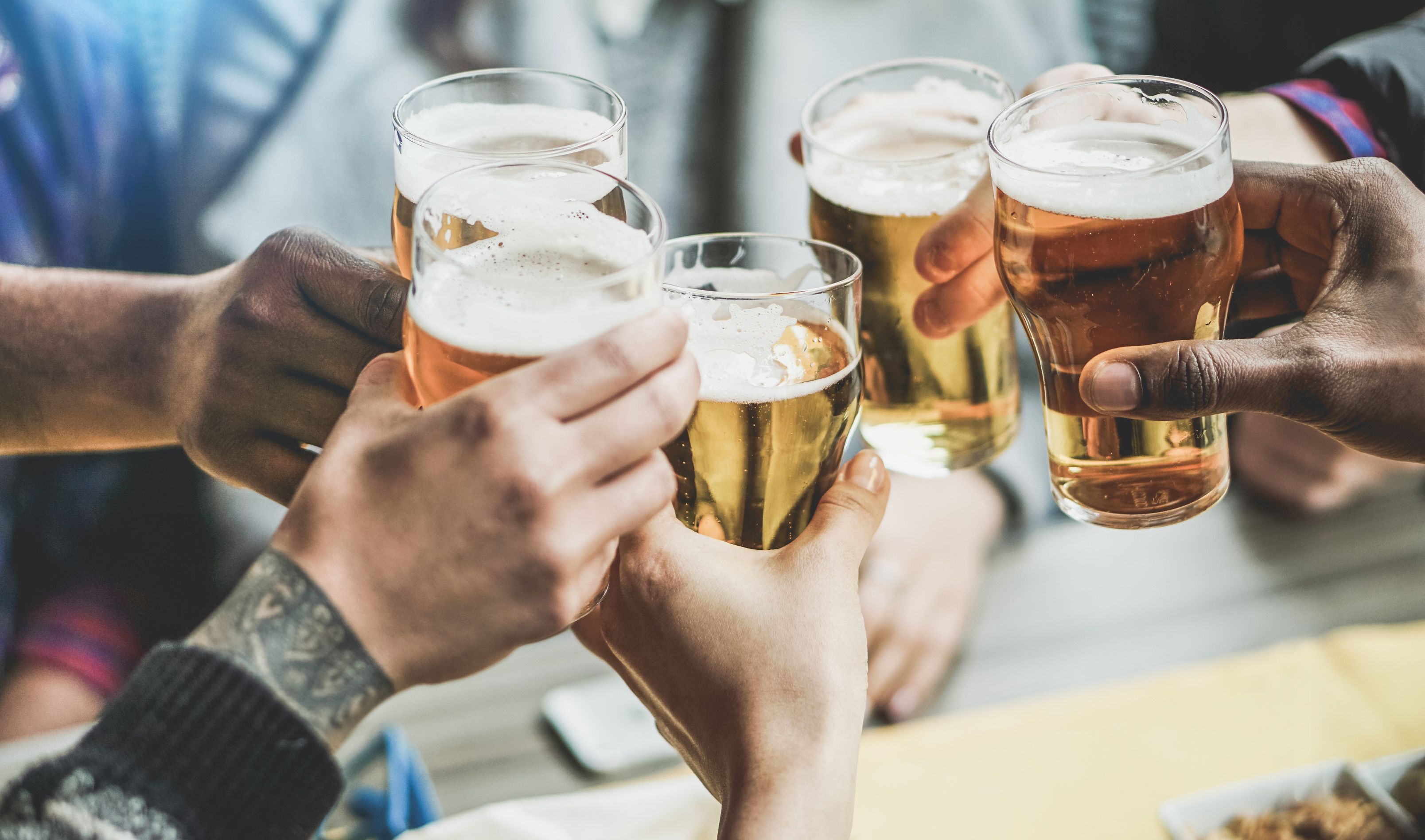 Menschen stoßen mit Bier an