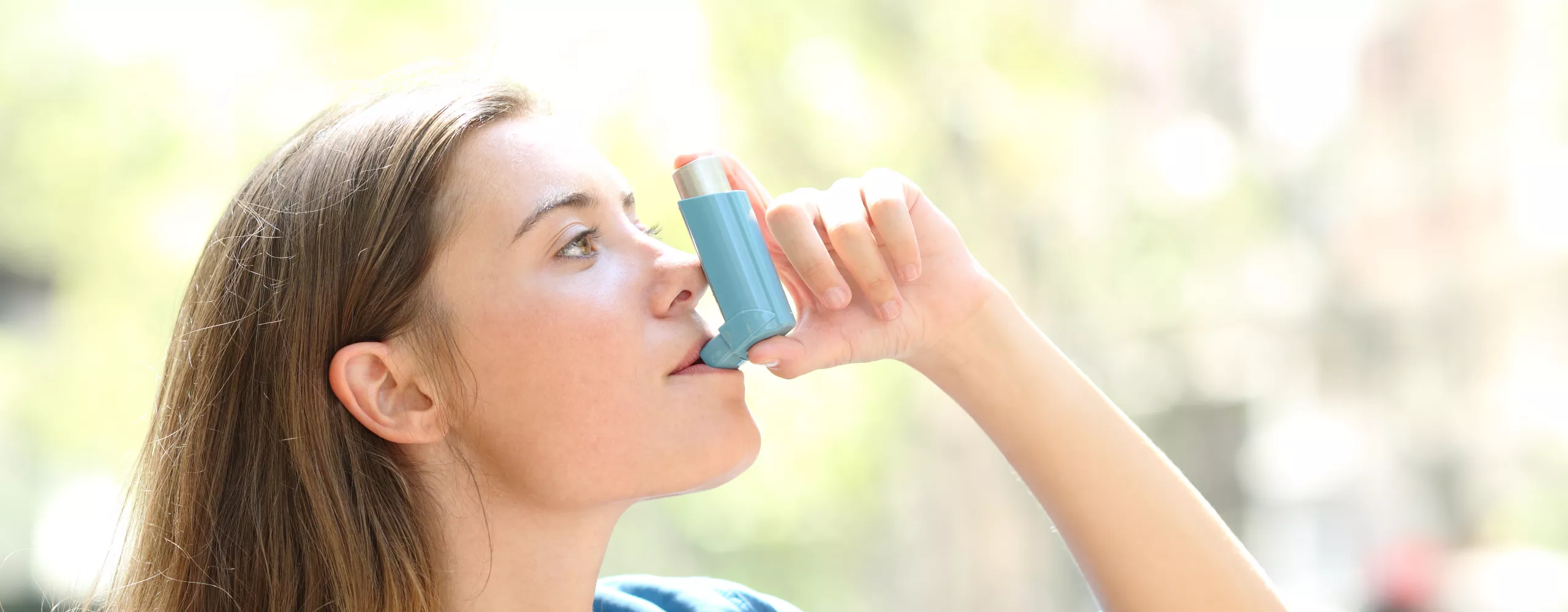 Frau nutzt ihr Asthma-Spray.