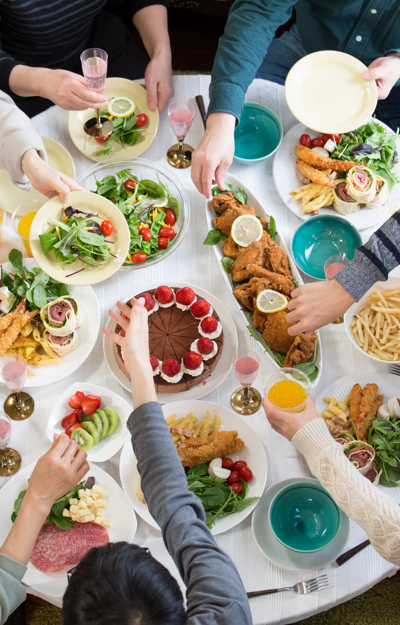 Familie an einem großen Esstisch mit viel Essen
