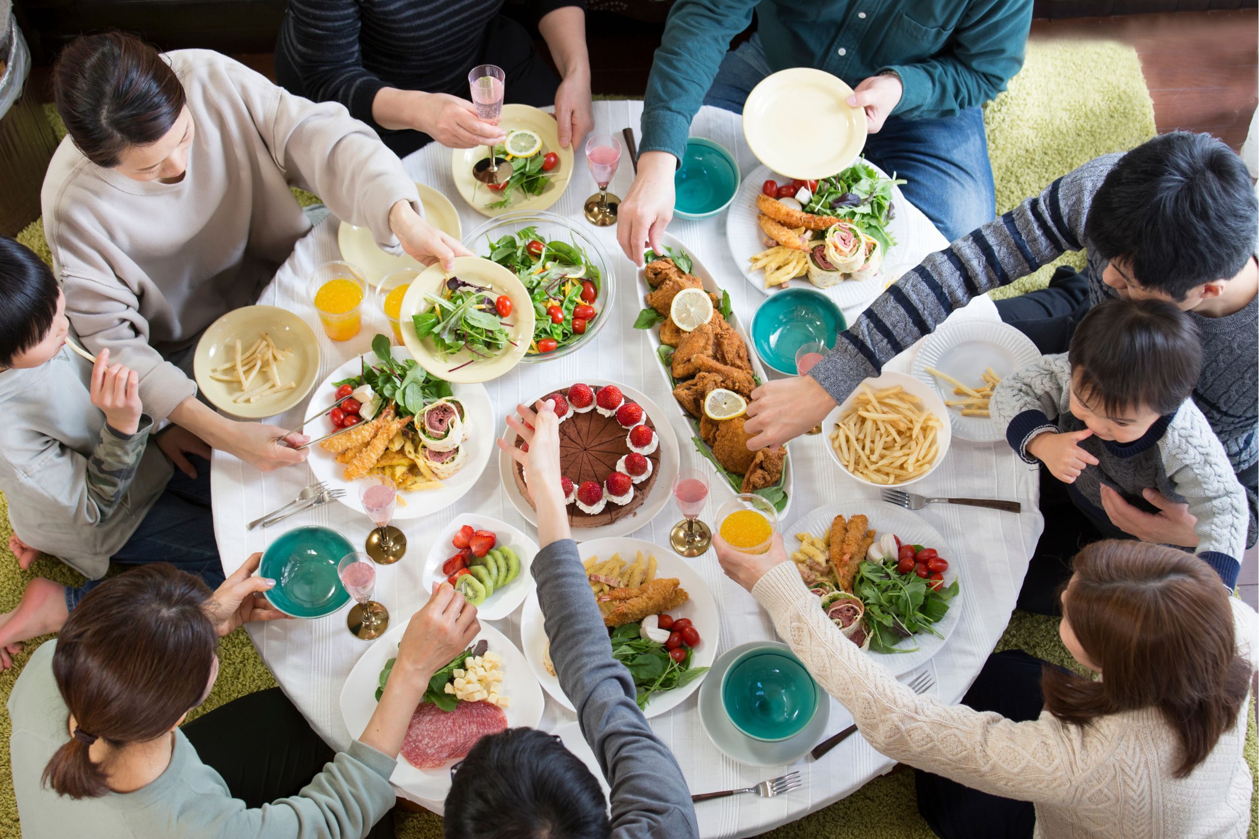 Familie an einem großen Esstisch mit viel Essen