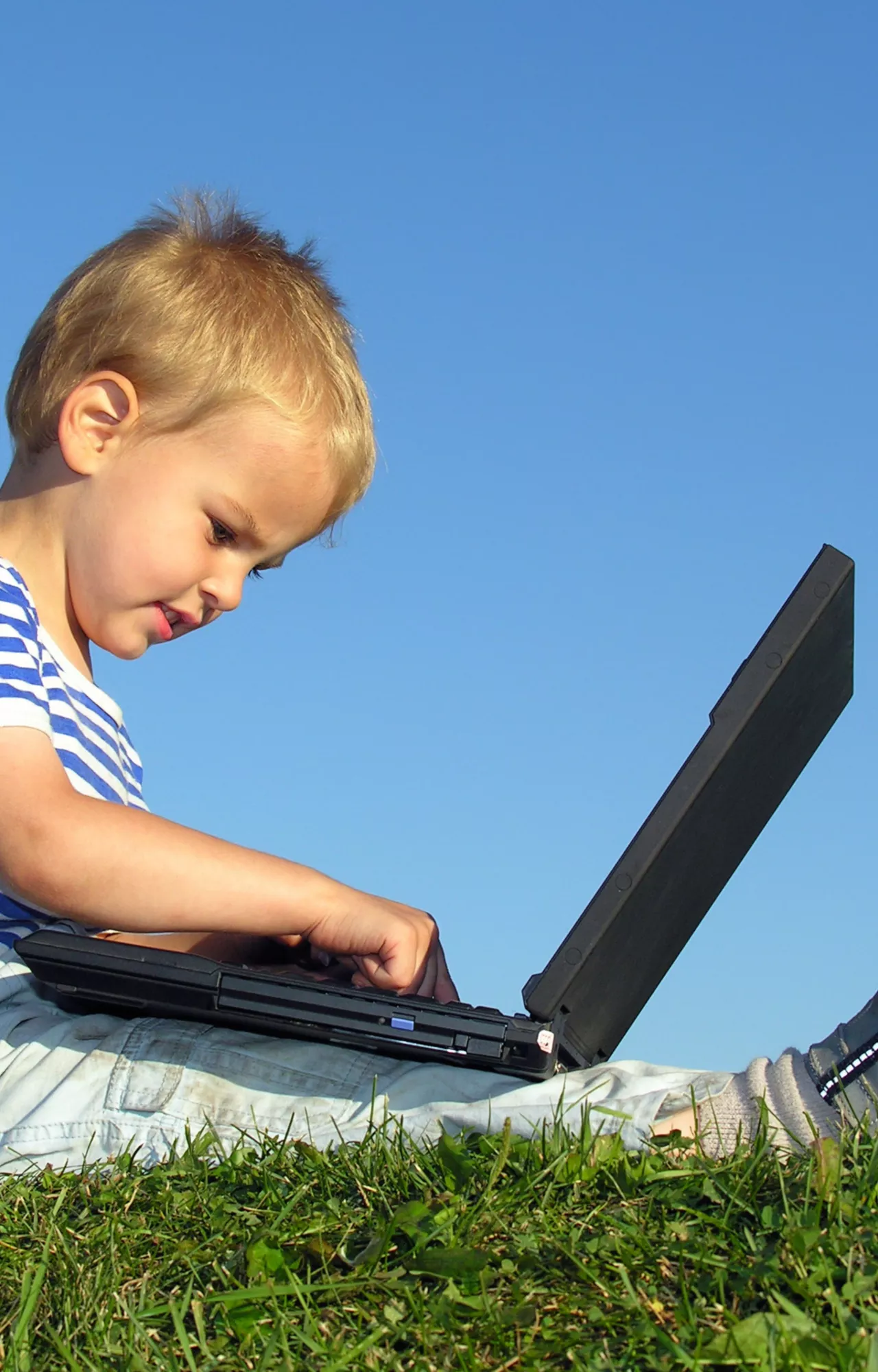 Kind sitzt vor dem Laptop