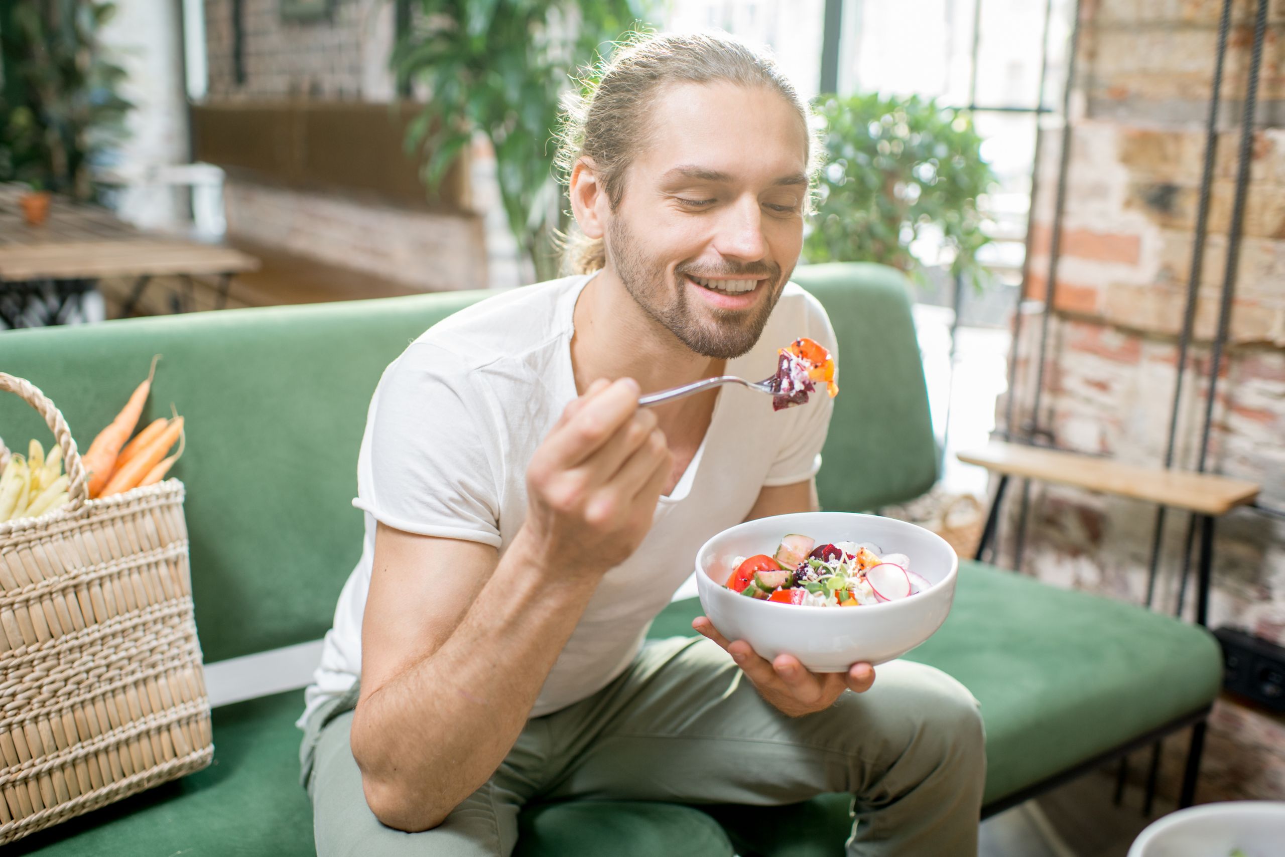Mann mit Essen auf dem Sofa