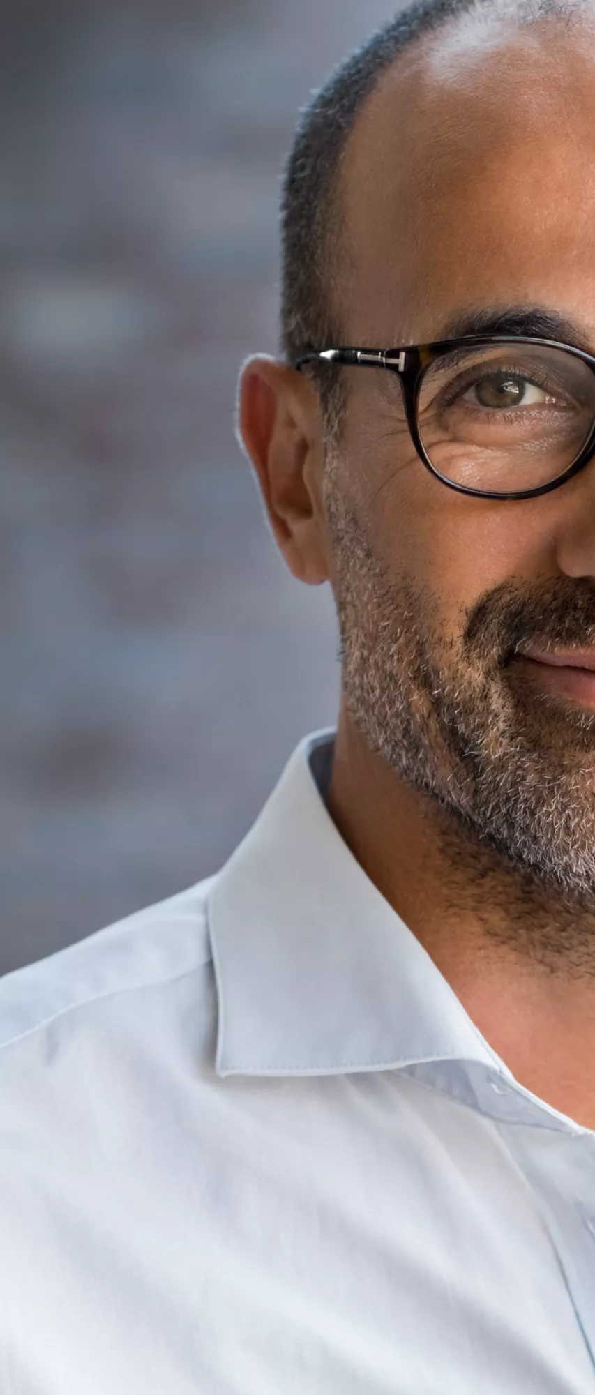 Mann mit Brille lächelt in die Kamera