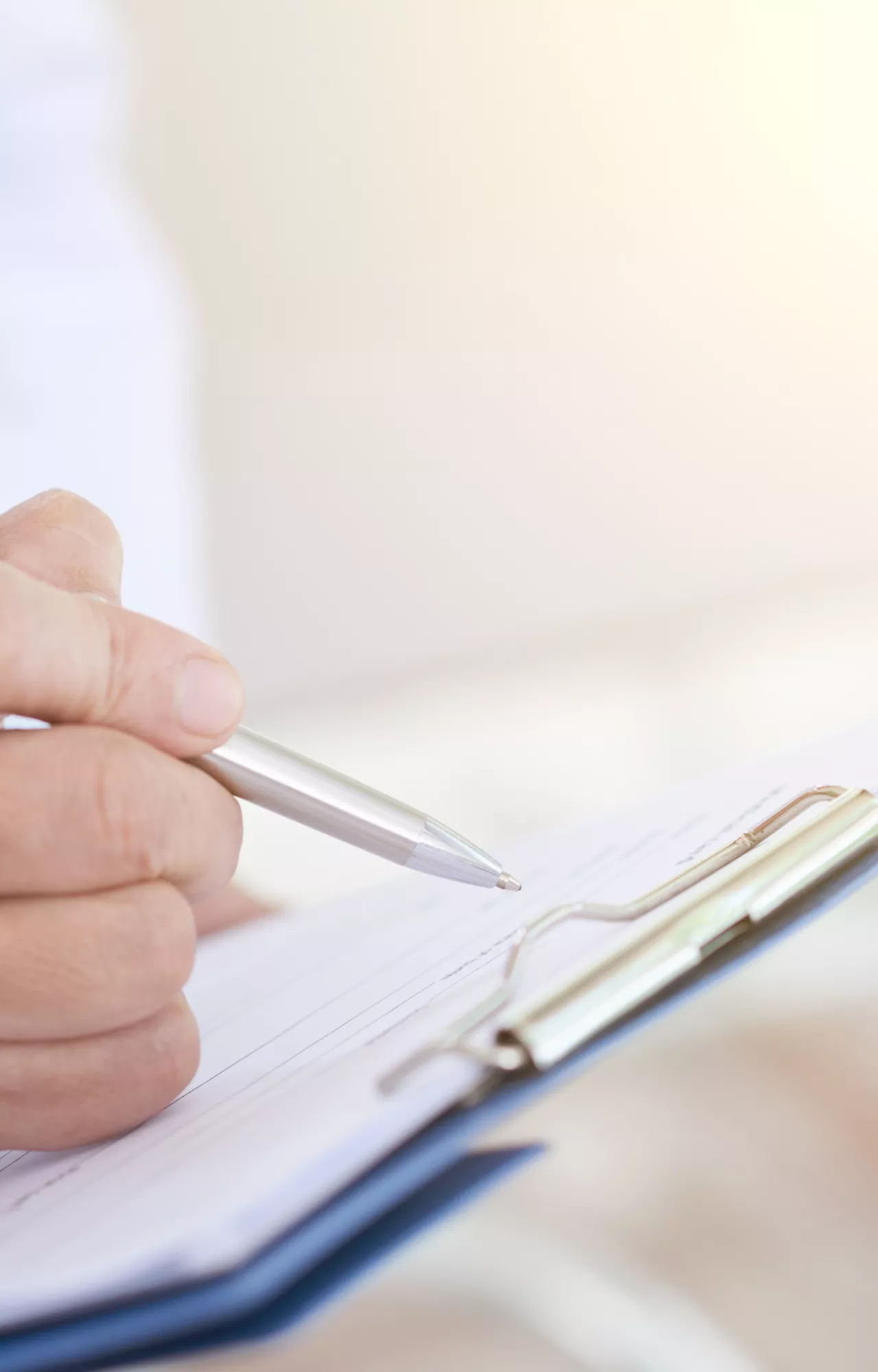 Mann schreibt auf Klemmbrett