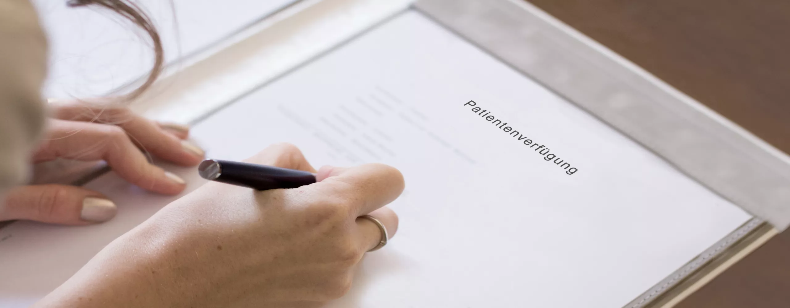 Frau unterschreibt Patientenverfügung