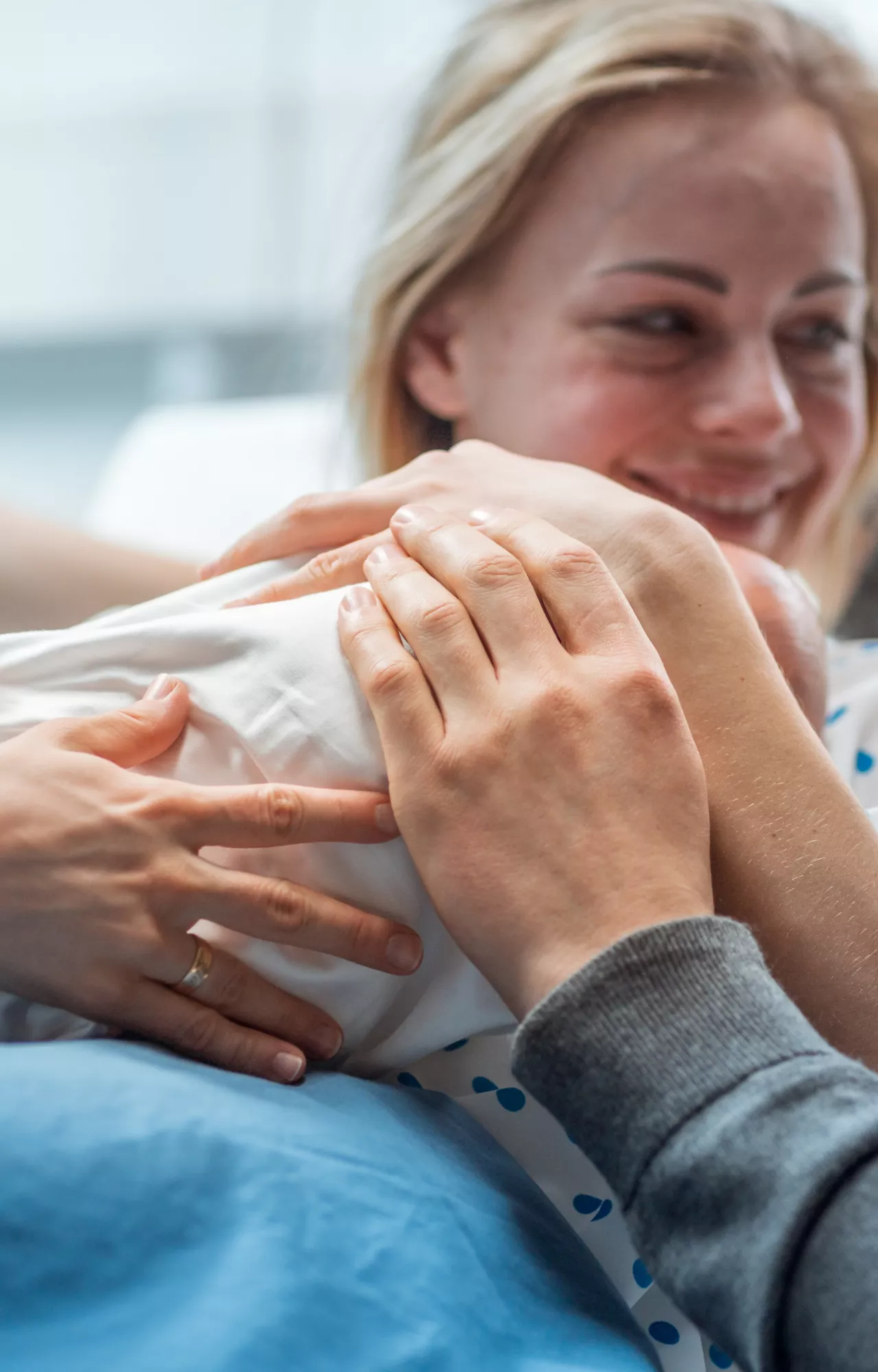 Frau mit Neugeborenem in der Hand