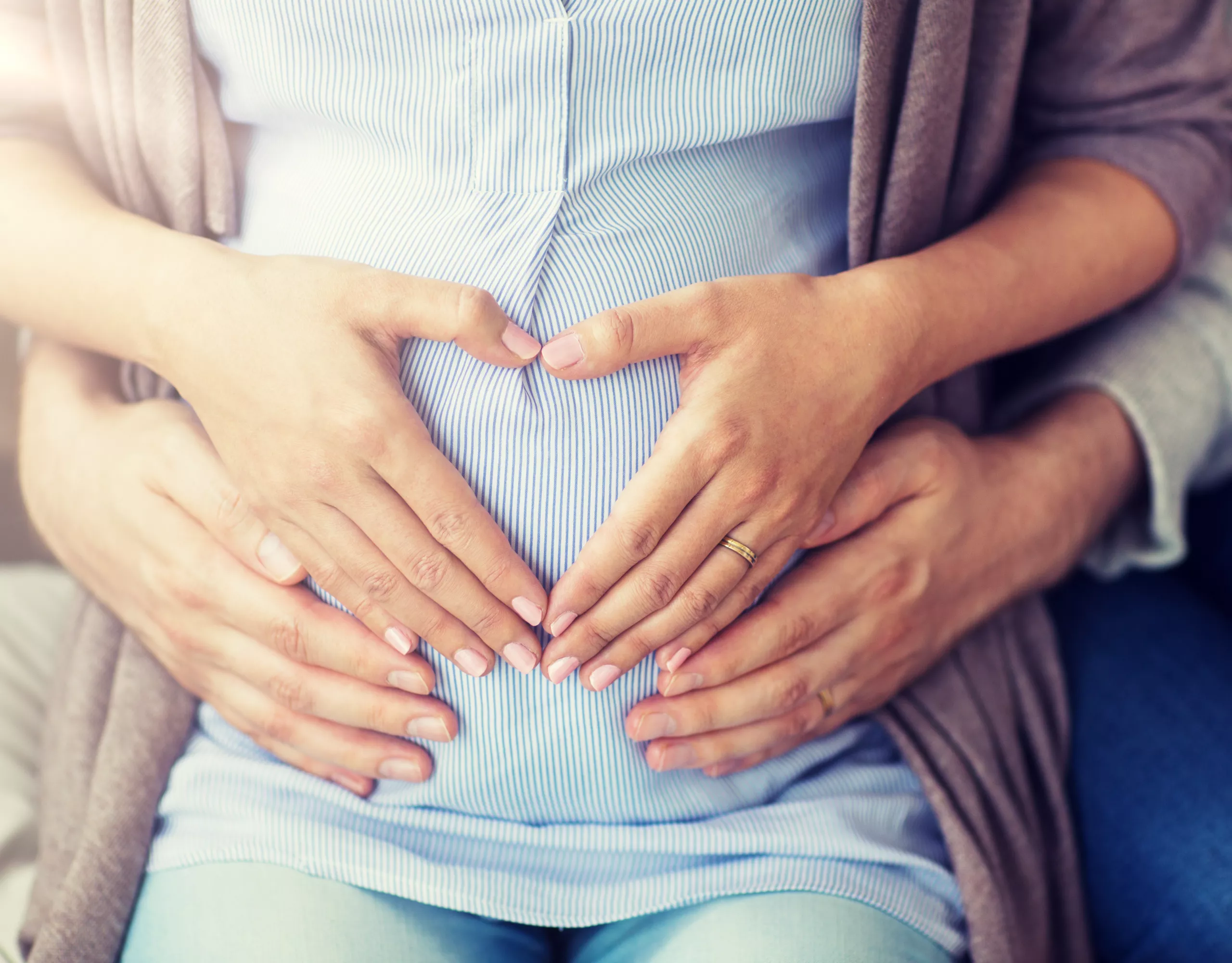 Frau und Mann halten gemeinsam den Babybauch