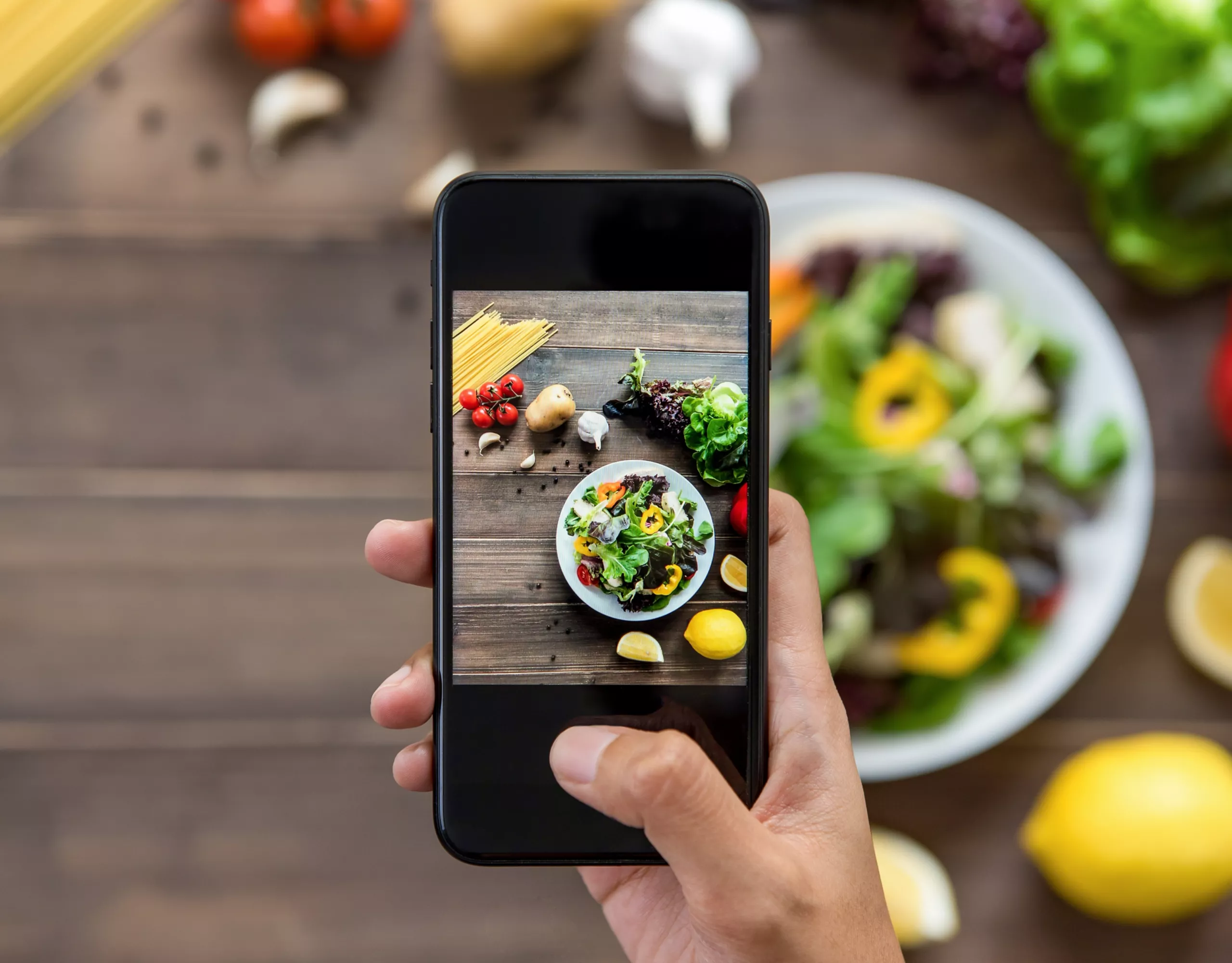 Person macht Foto von Essen mit Smartphone