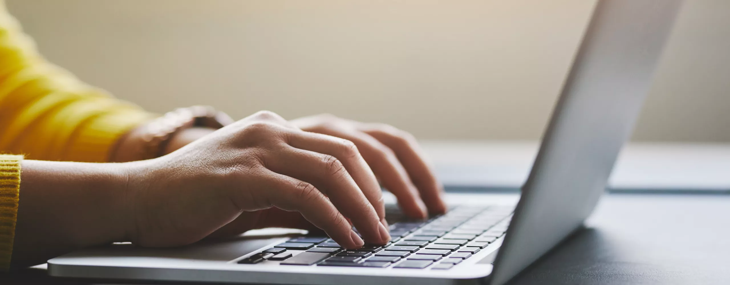 Frau tippt auf der Tastatur eines Laptops