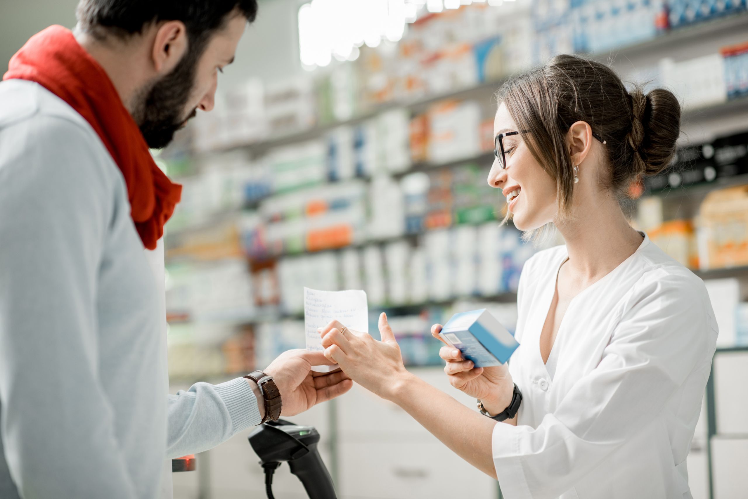 Apothekerin berät Mann in der Apotheke