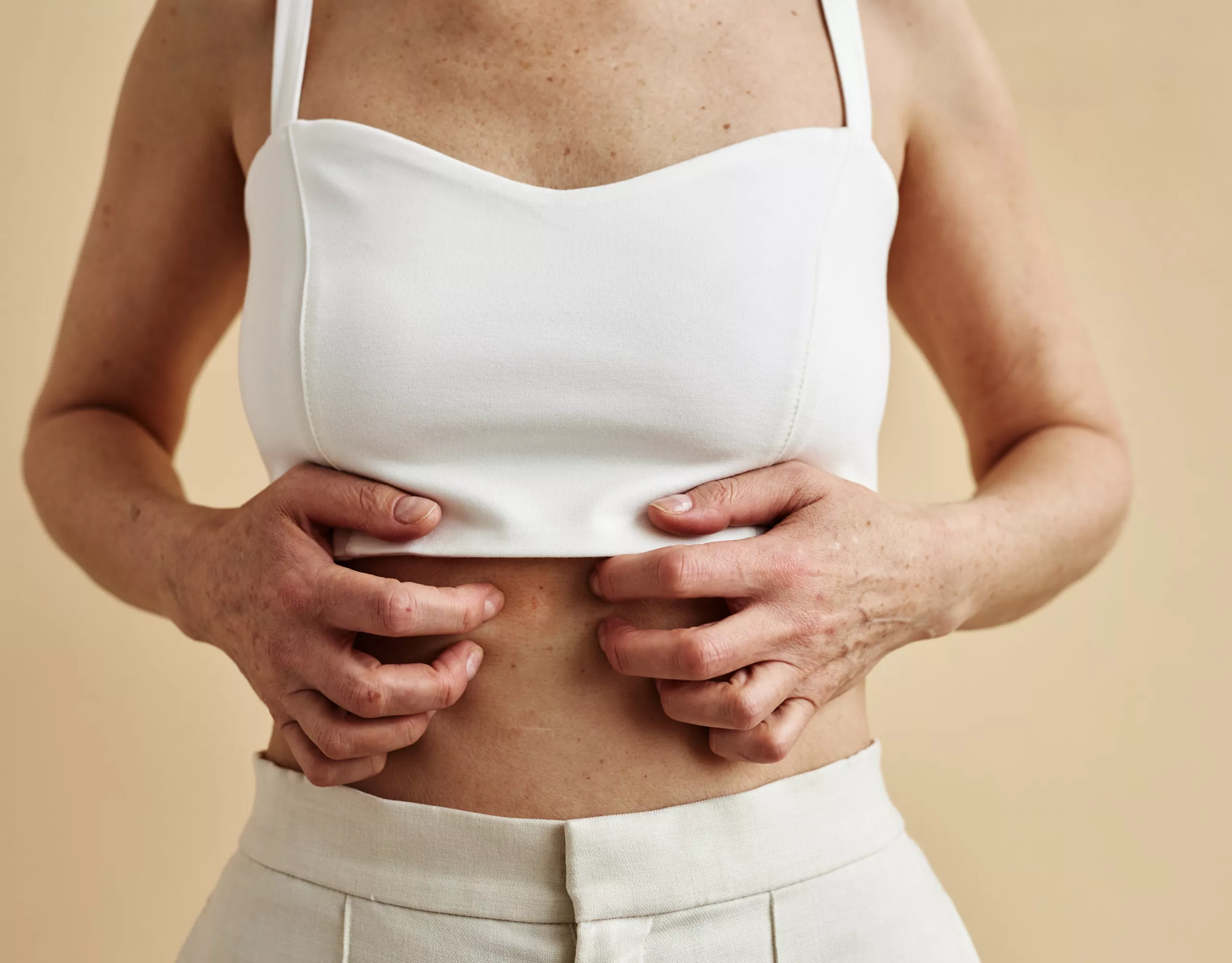 Frau kratzt ihren Bauch