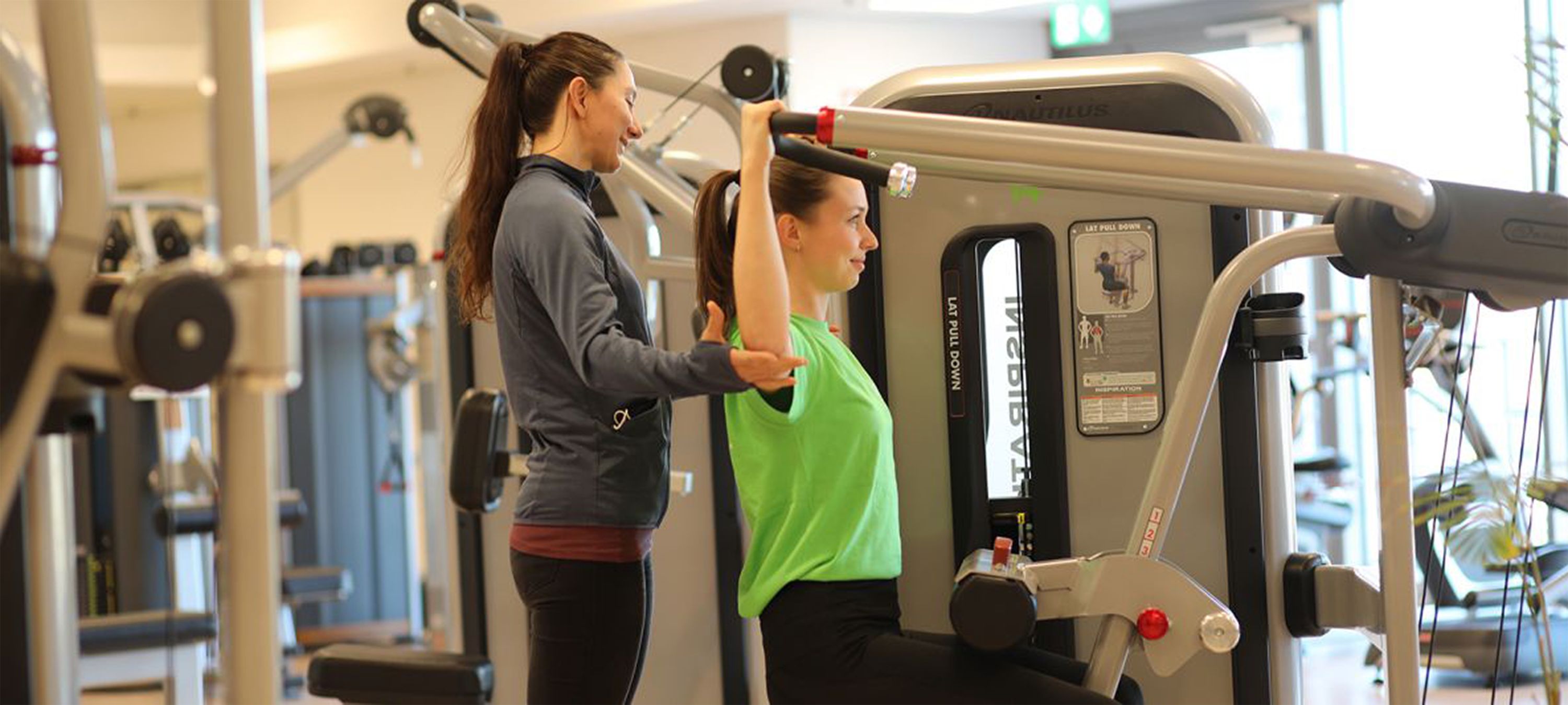 Trainerin hilft Frau beim trainieren