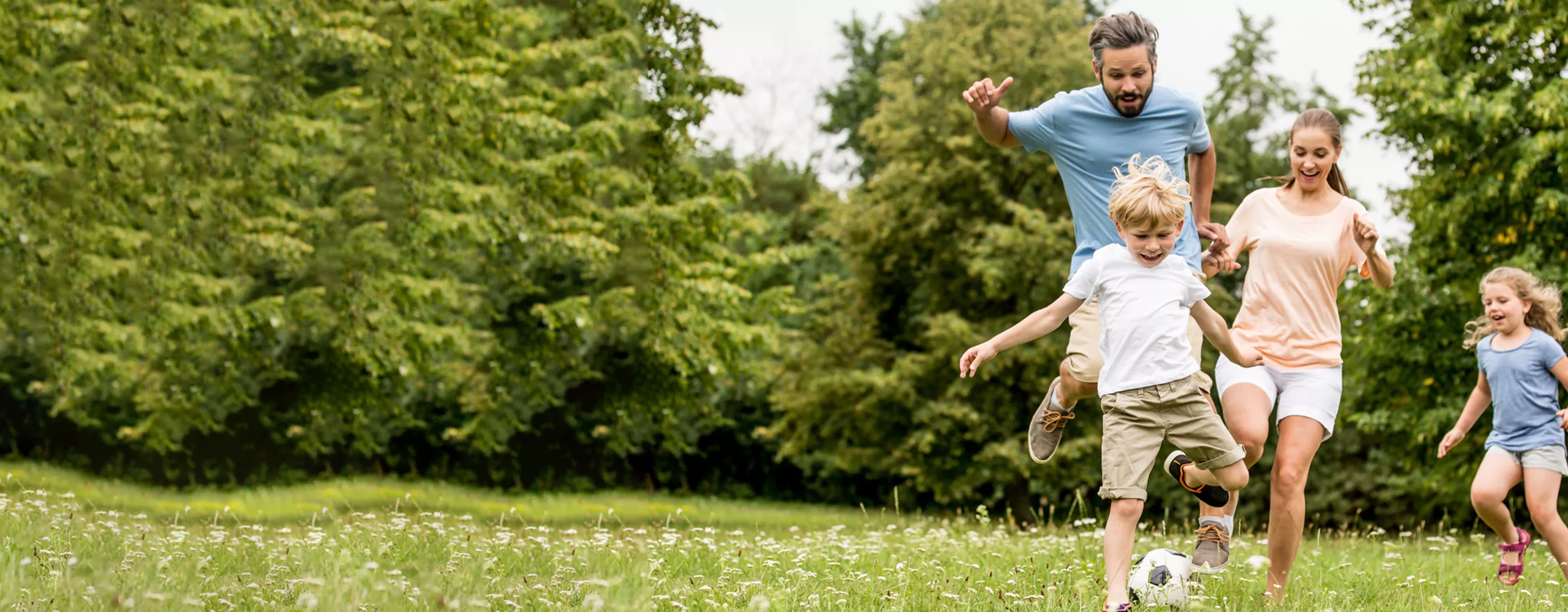Familie spielt Fußball auf der Wiese