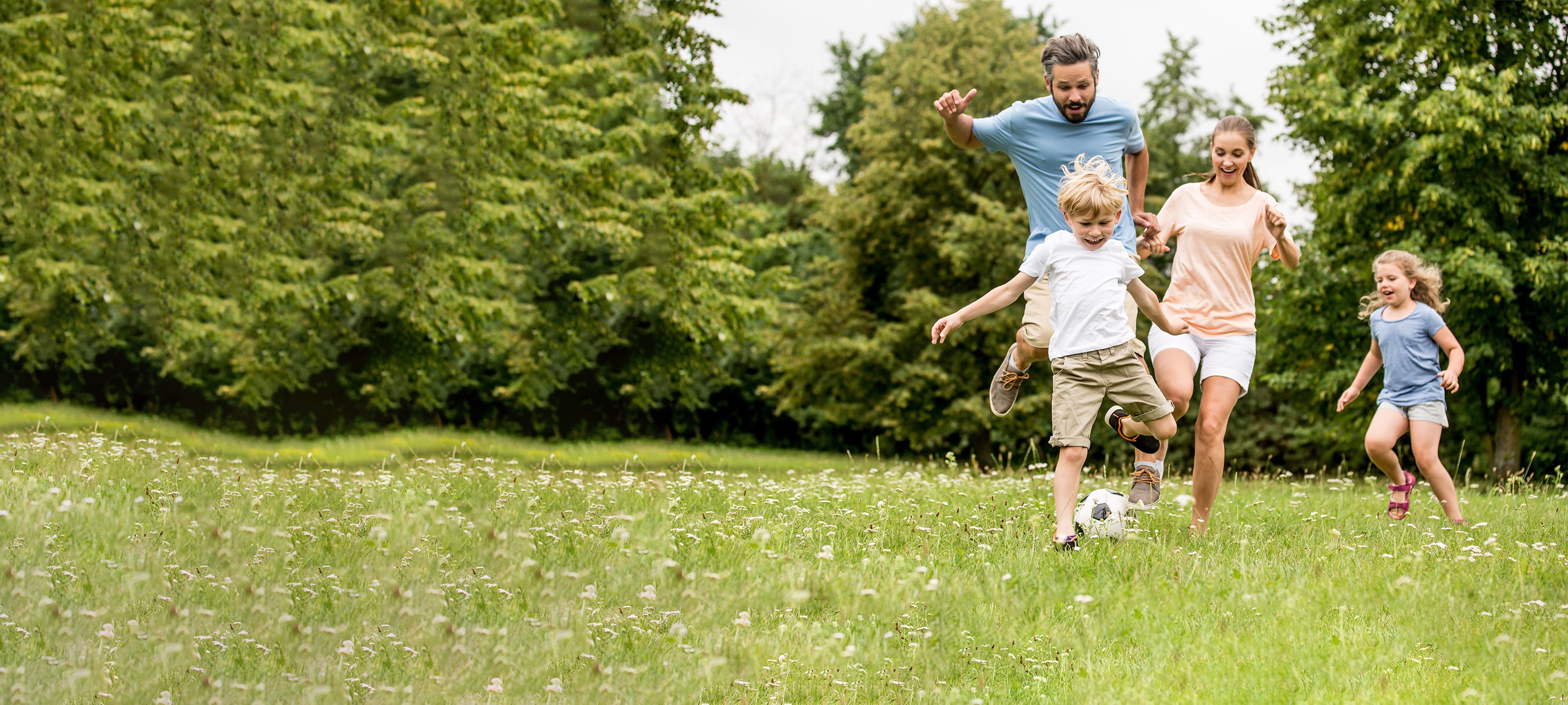 Familie spielt Fußball auf der Wiese