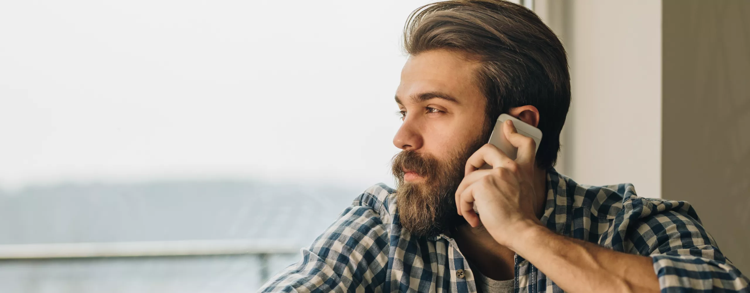 Mann sieht nachdenklich aus dem Fenster