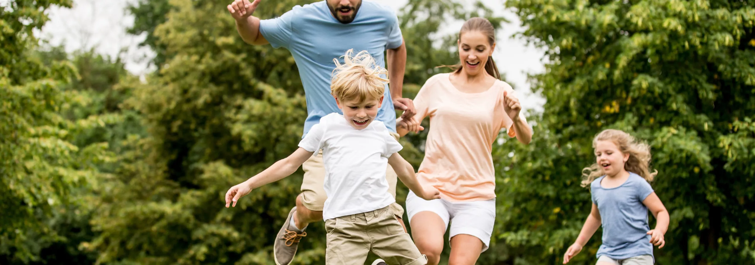 Familie spielt zusammen Fußball auf einer Wiese