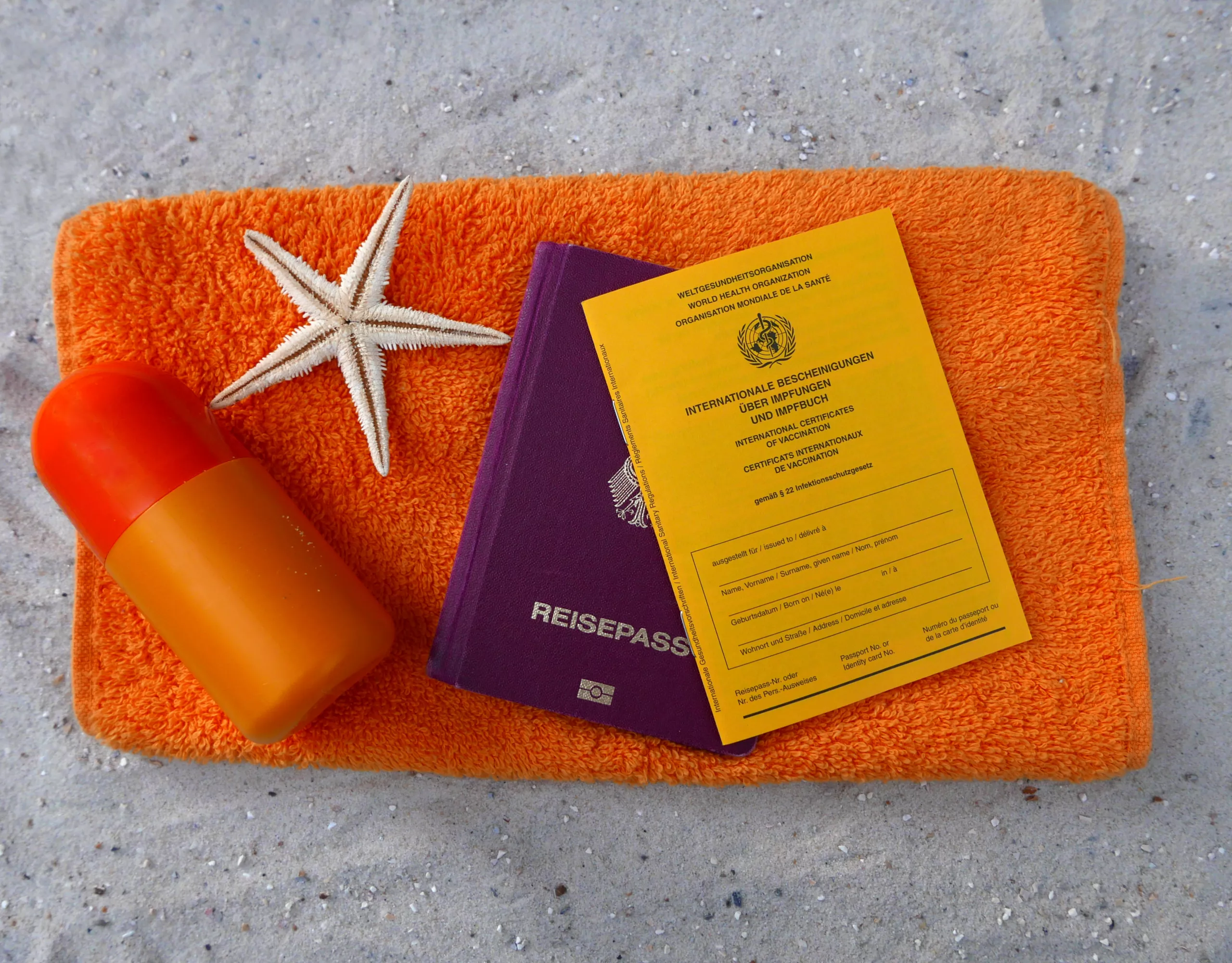 Reisepass und Impfpass liegen auf Handtuch