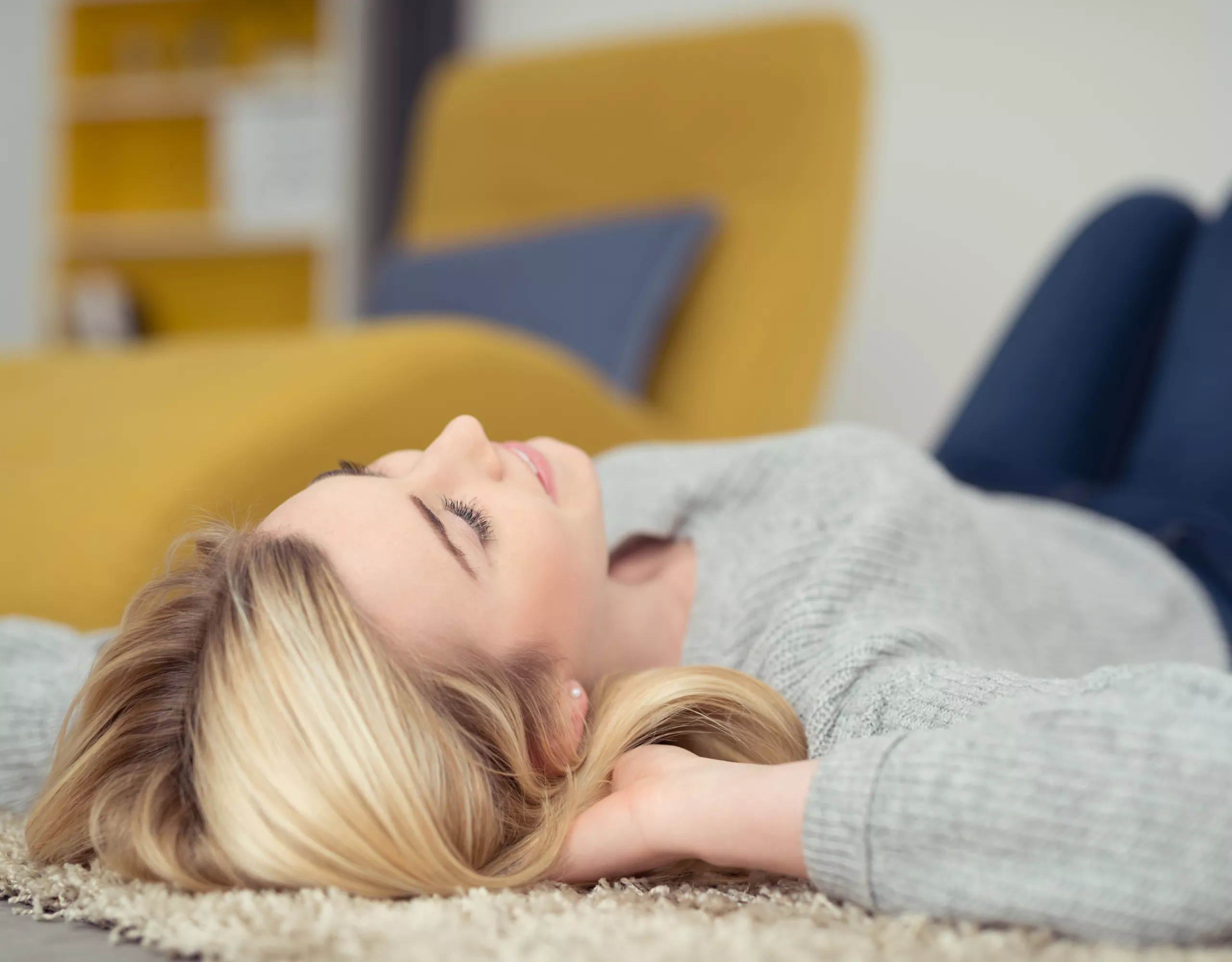 Frau liegt auf Teppich