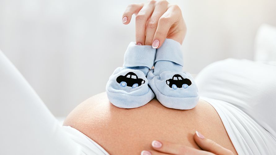 Babyschuhe auf dem Babybauch