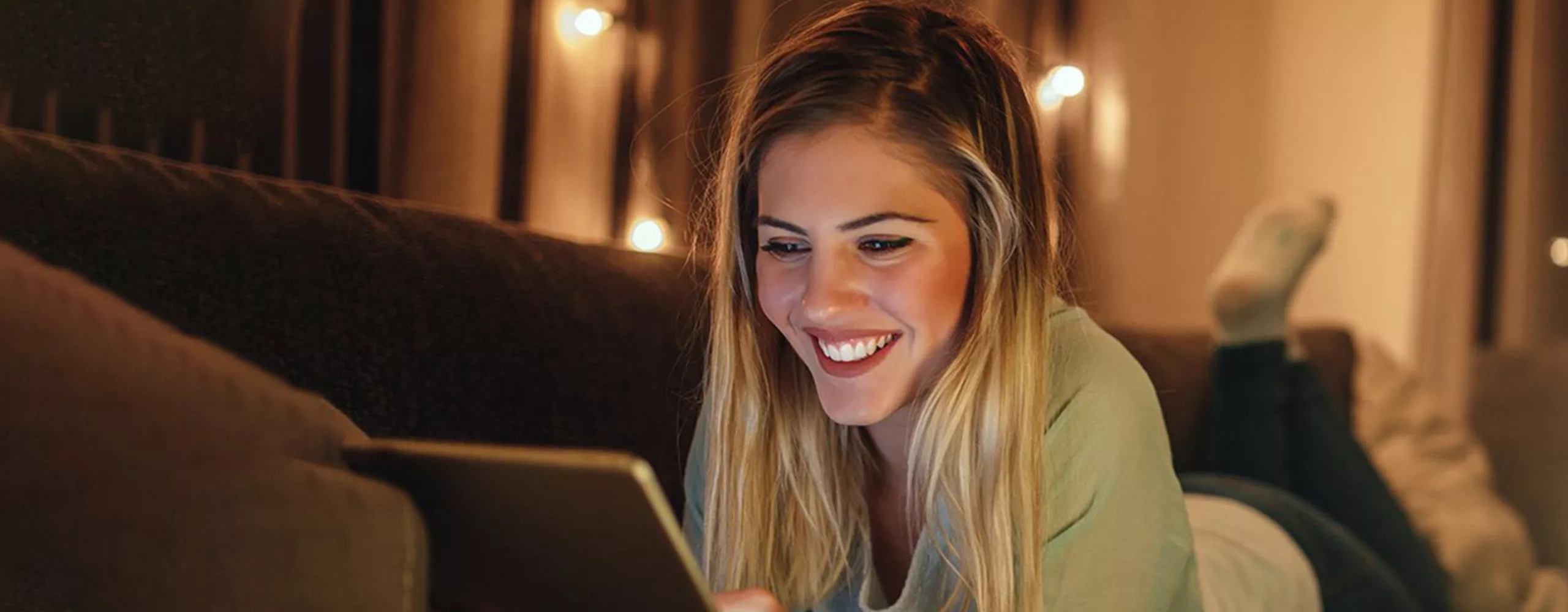 Frau mit Tablet auf dem Sofa