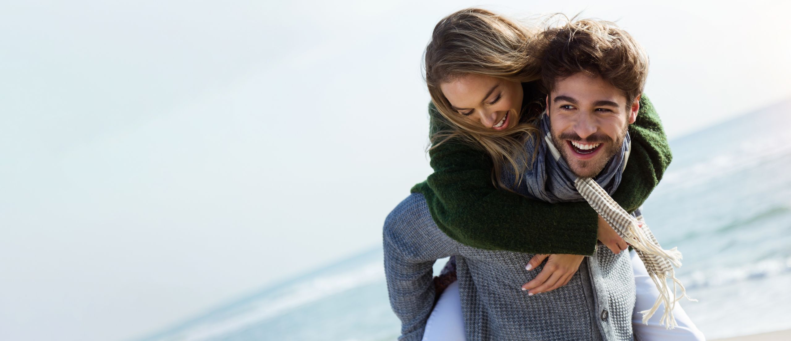 Mann und Frau lachend am Strand