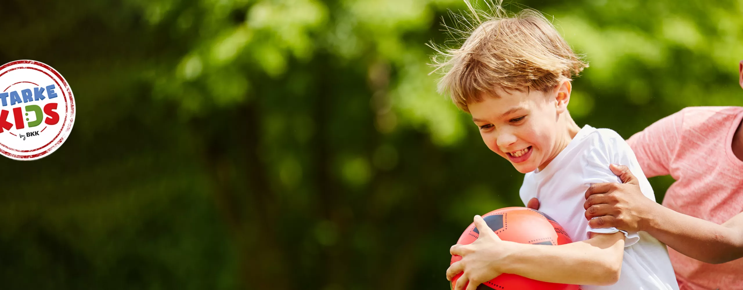 Kinder beim Spielen mit Ball in der Natur