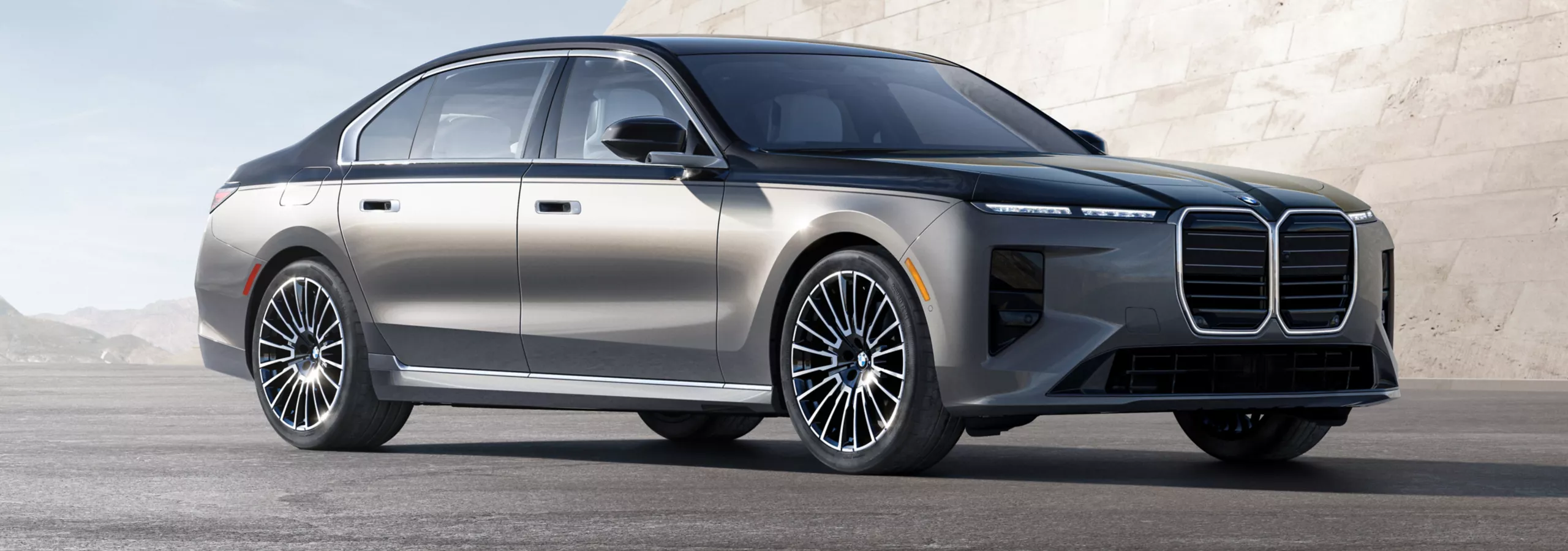 A BMW 7 Series parked in front of a modern backdrop