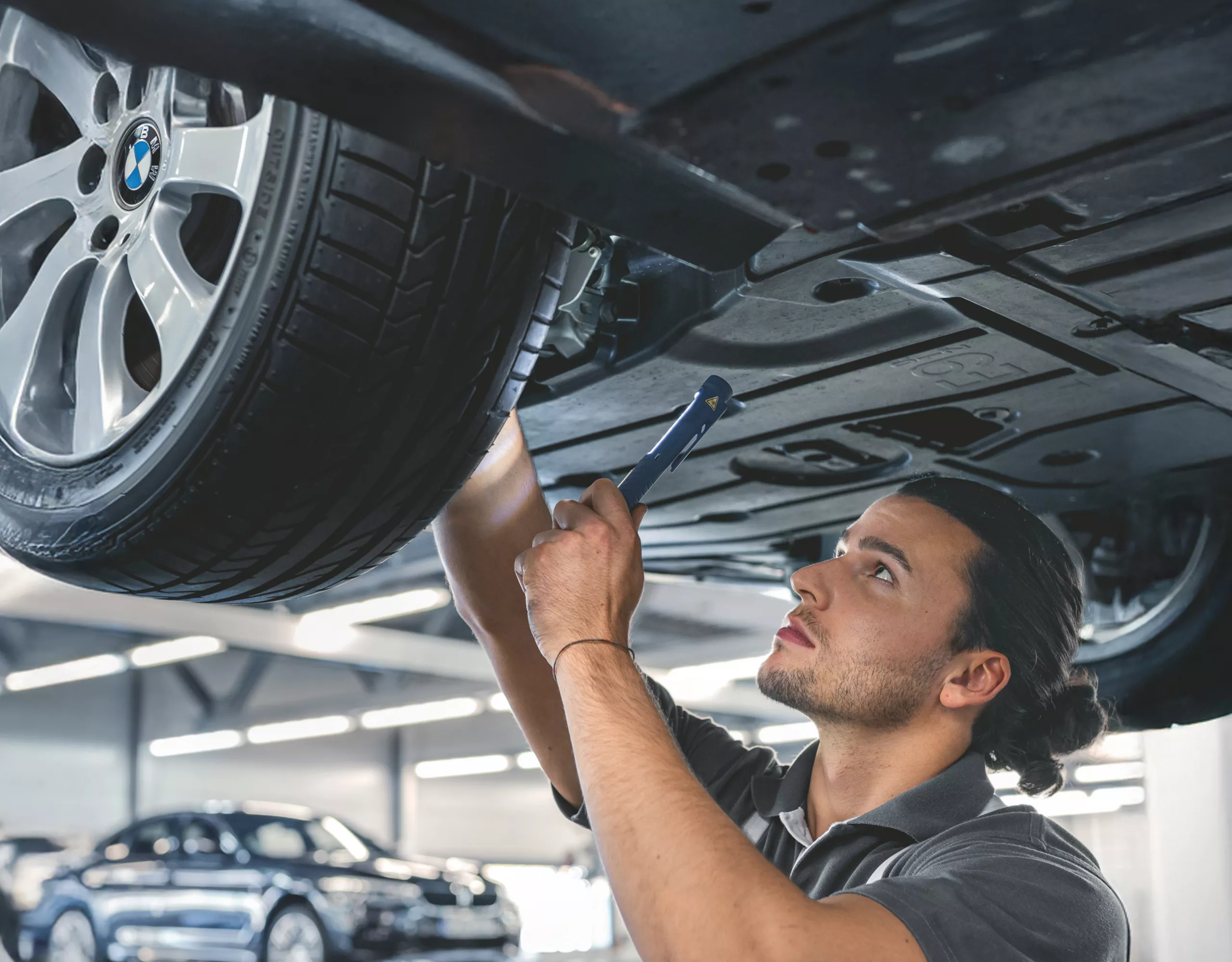 Mechanic working under car in garage