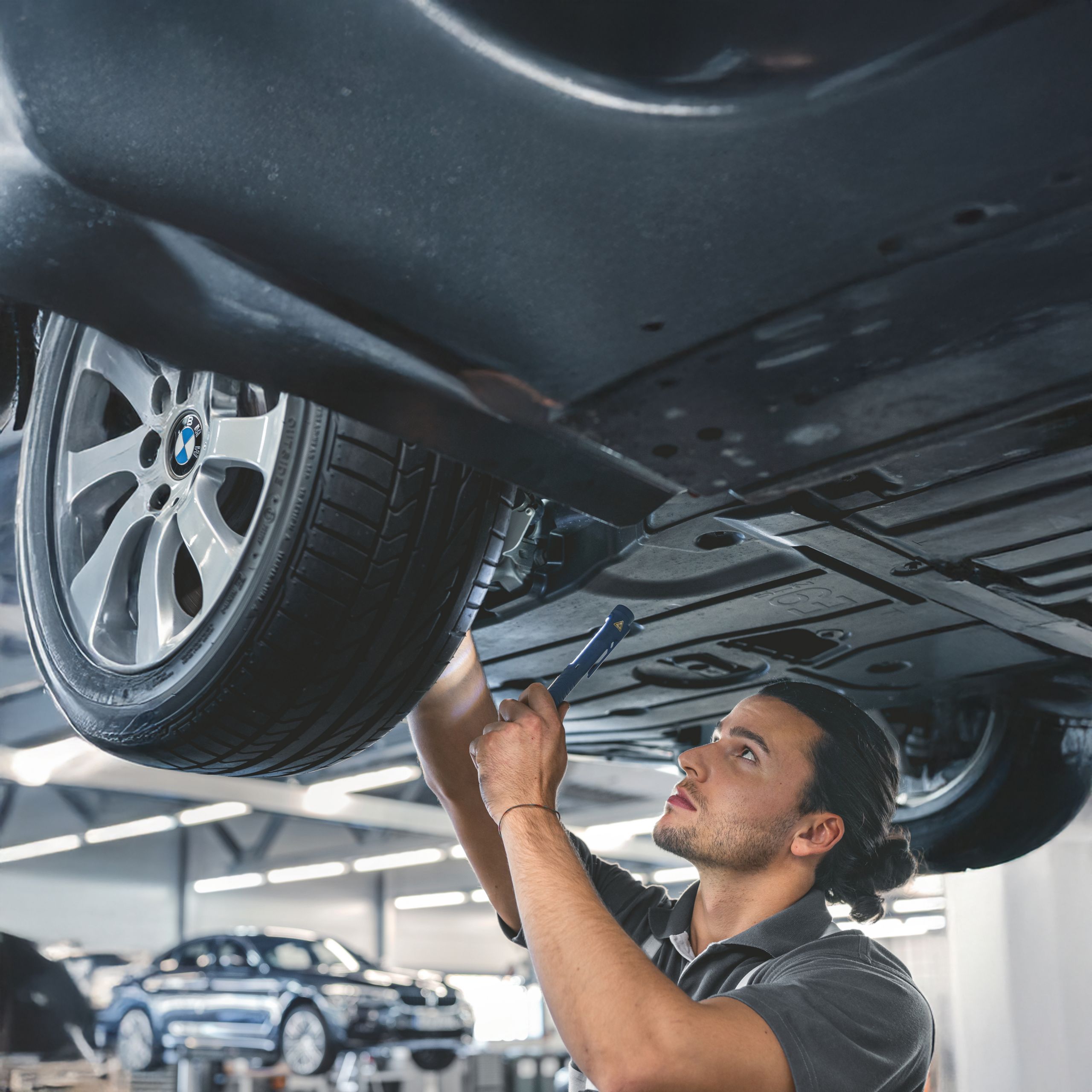 Mechanic working under car in garage
