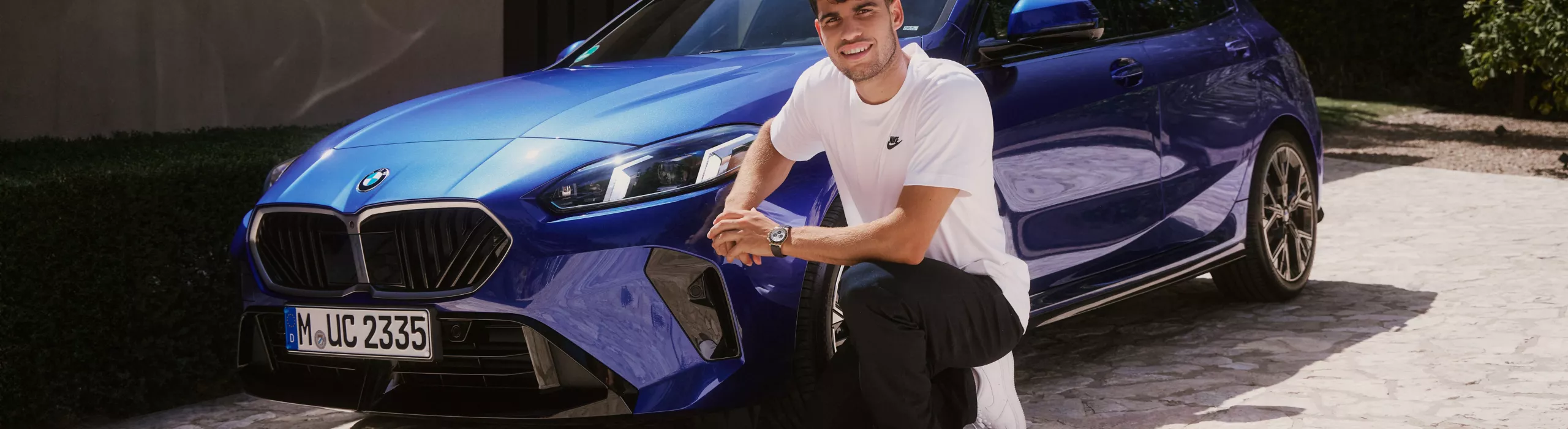 Carlos Alcaraz in front of a BMW 1 Series