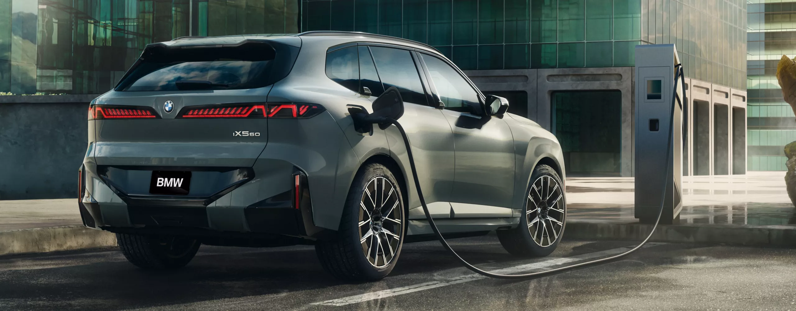 A BMW iX5 60 xDrive charges on the roof of a building in a modern city setting.
