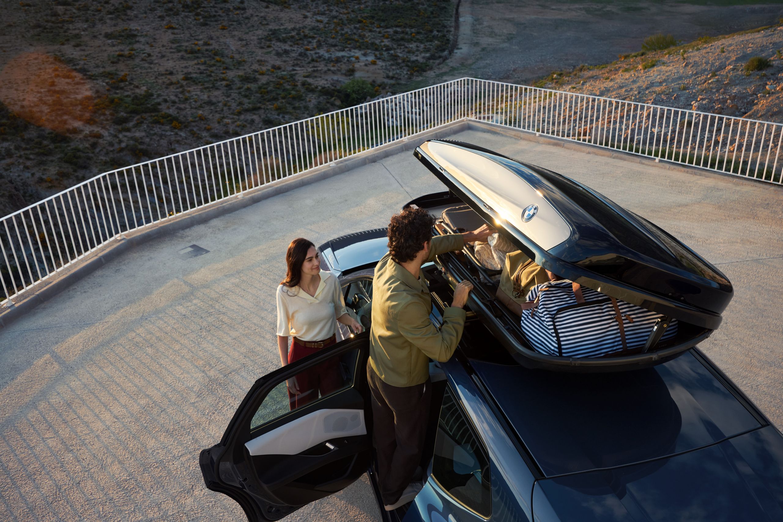 Couple loads rooftop box of a BMW iX3