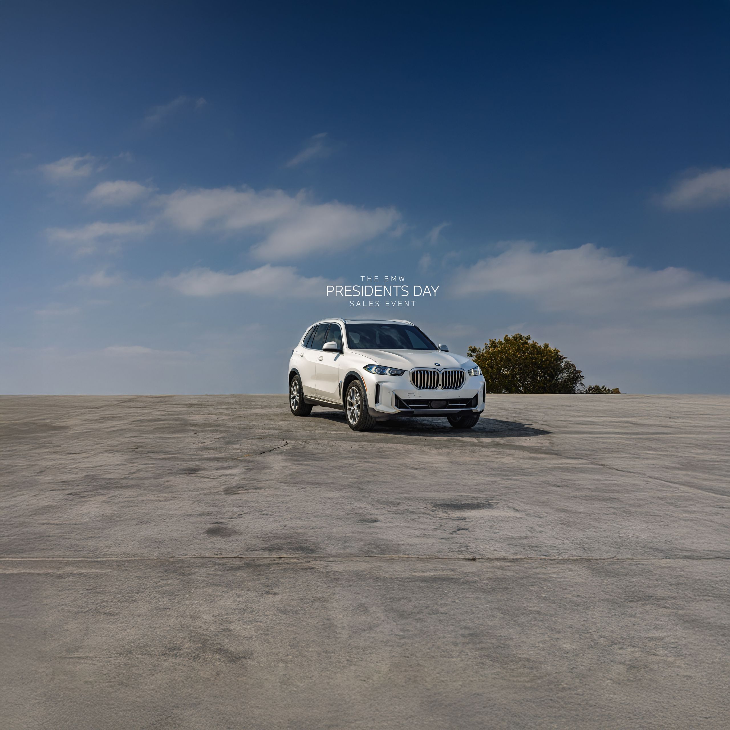 A BMW X5 sits parked on a concrete platform