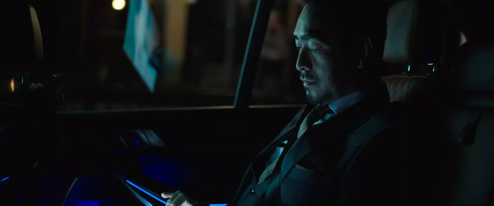 Man riding in back of BMW at night