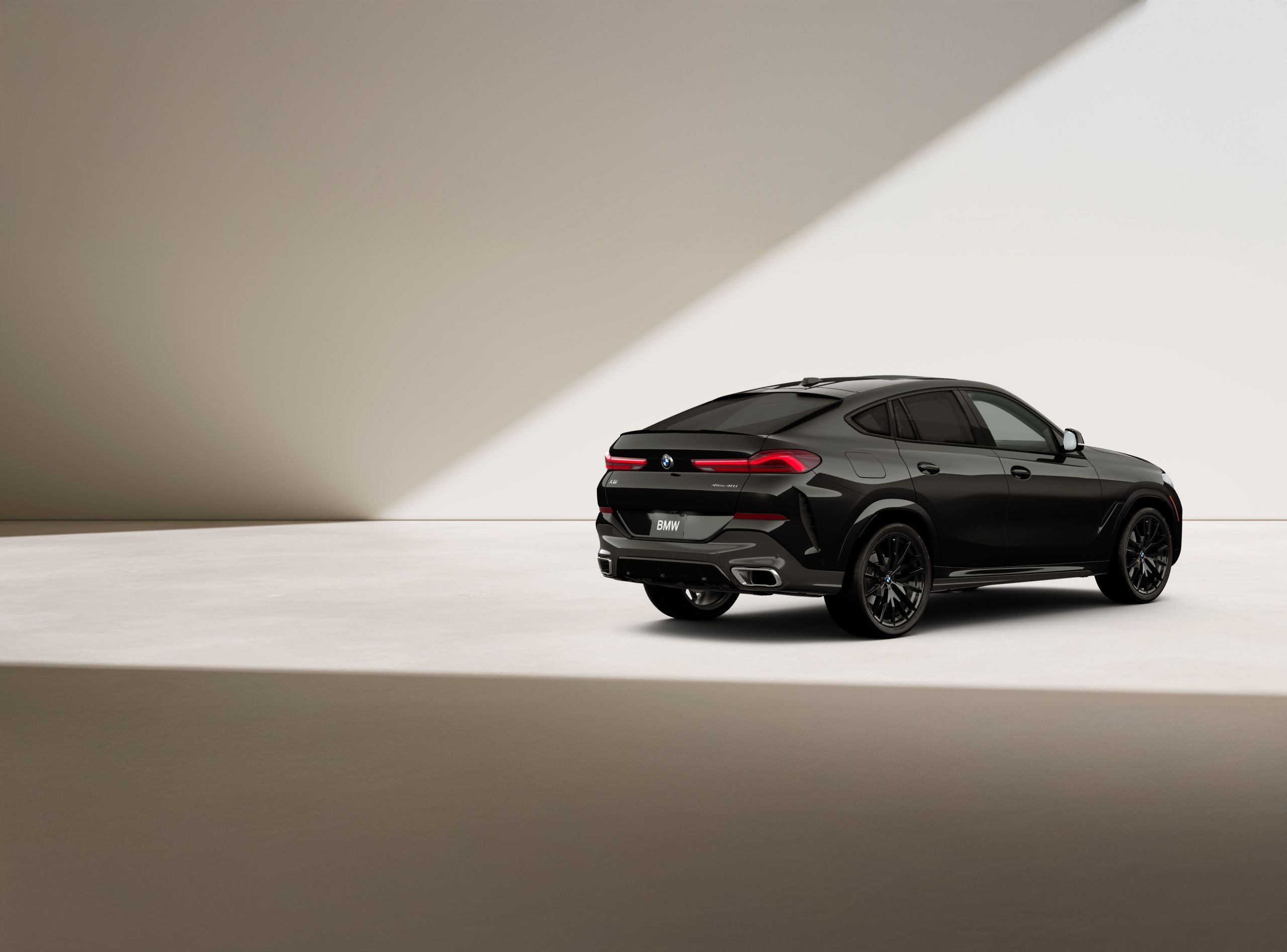 A BMW X6 SUV Highlights is parked in the sunlight in front of a brick building