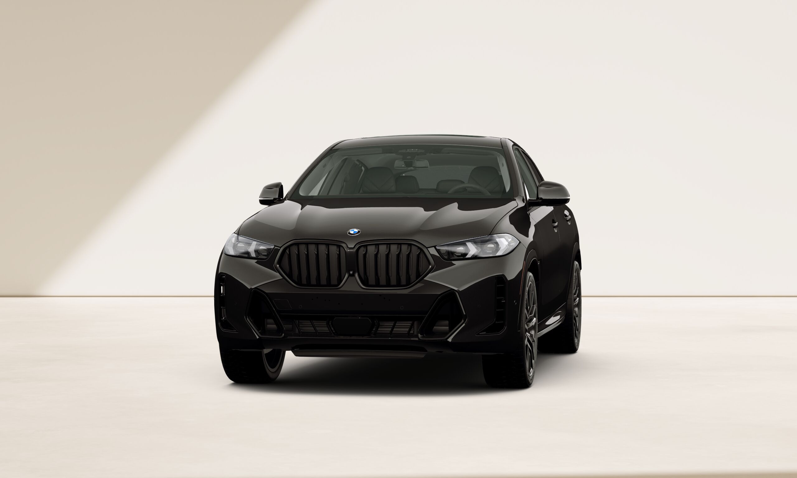 A BMW X6 SUV with M Sport package Pro is parked in front of a hangar door