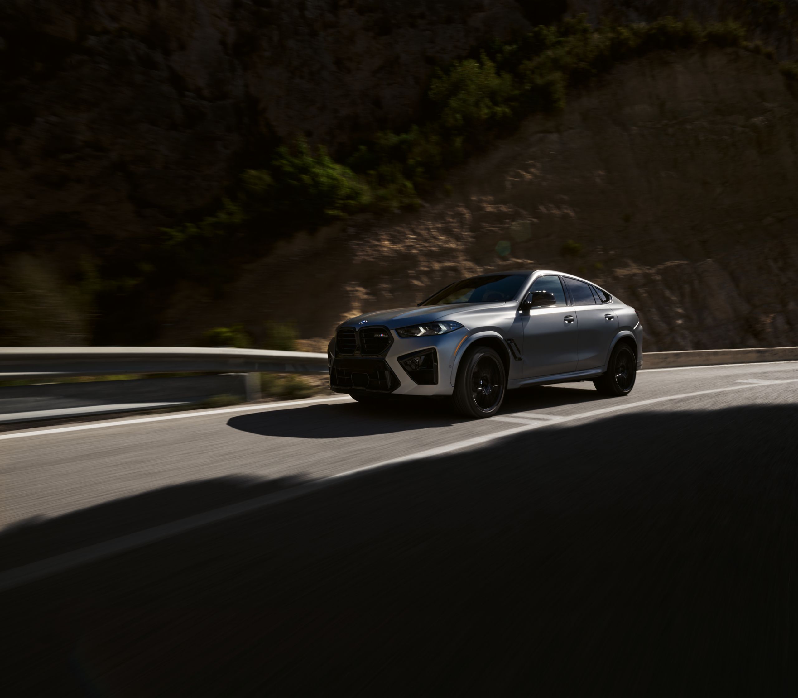 BMW X6 M Competition driving through a canyon