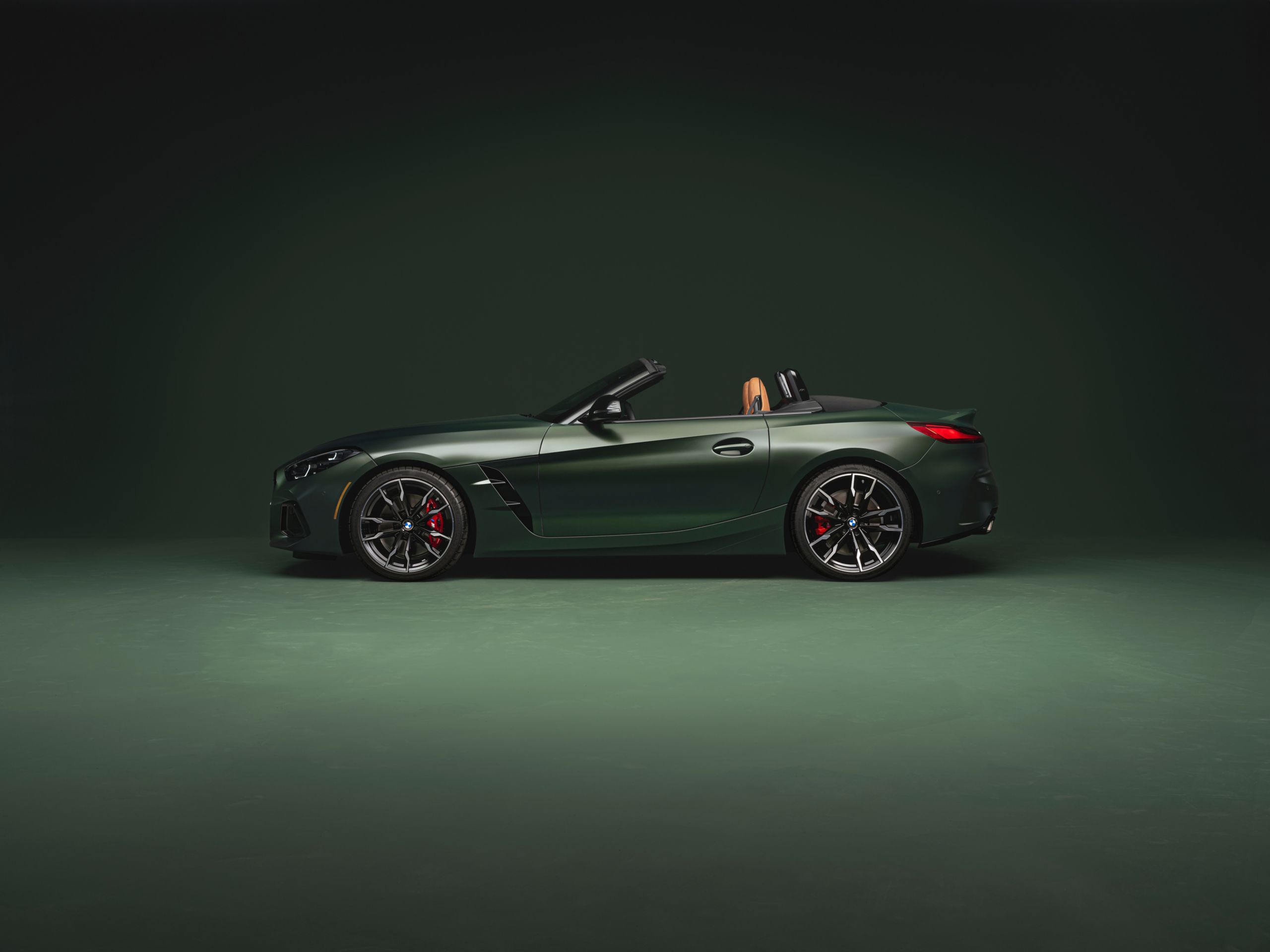 A BMW convertible parked in a dark studio space.