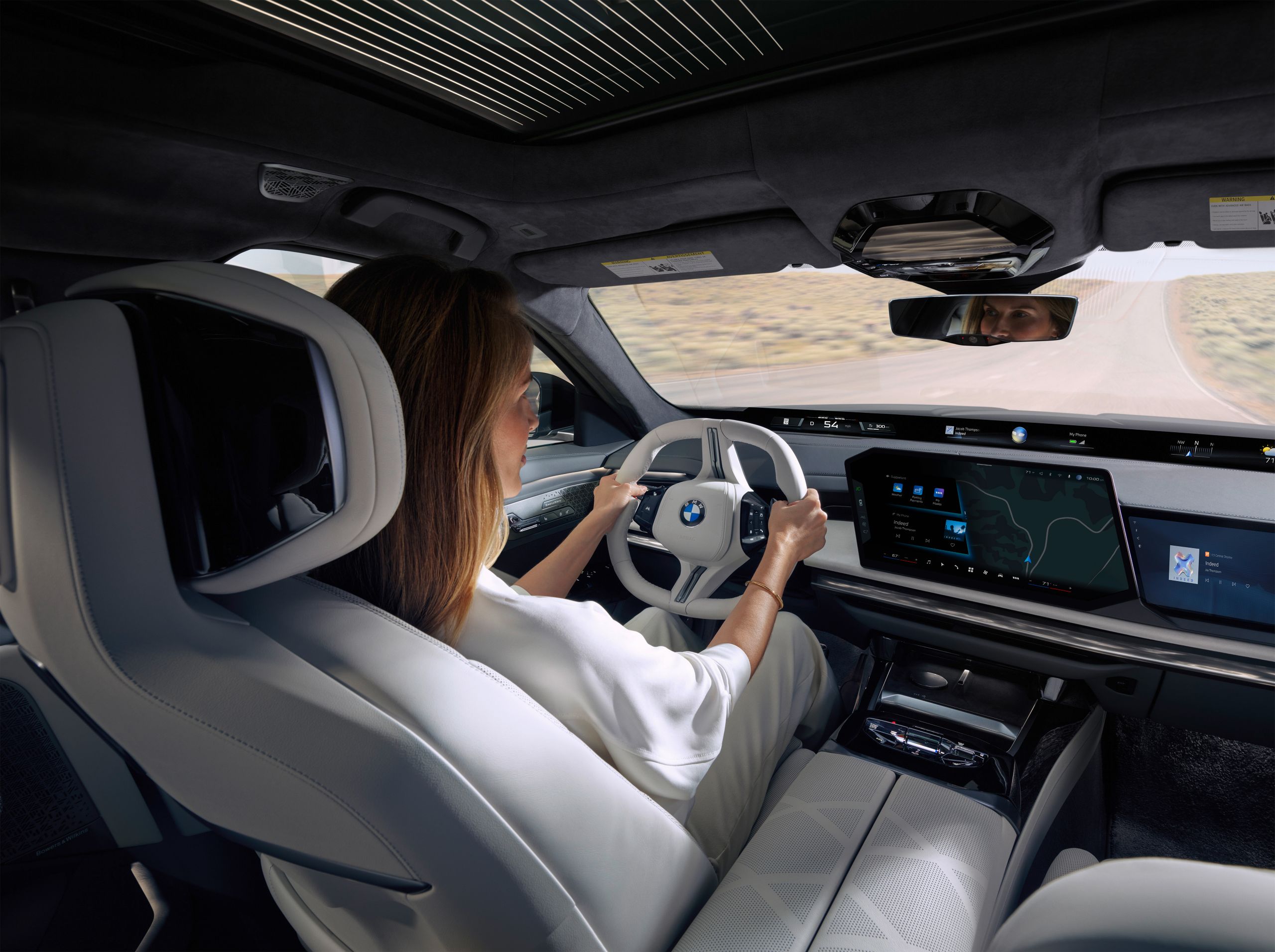 View from the rear seat bench to the driver, the steering wheel and the central information display.
