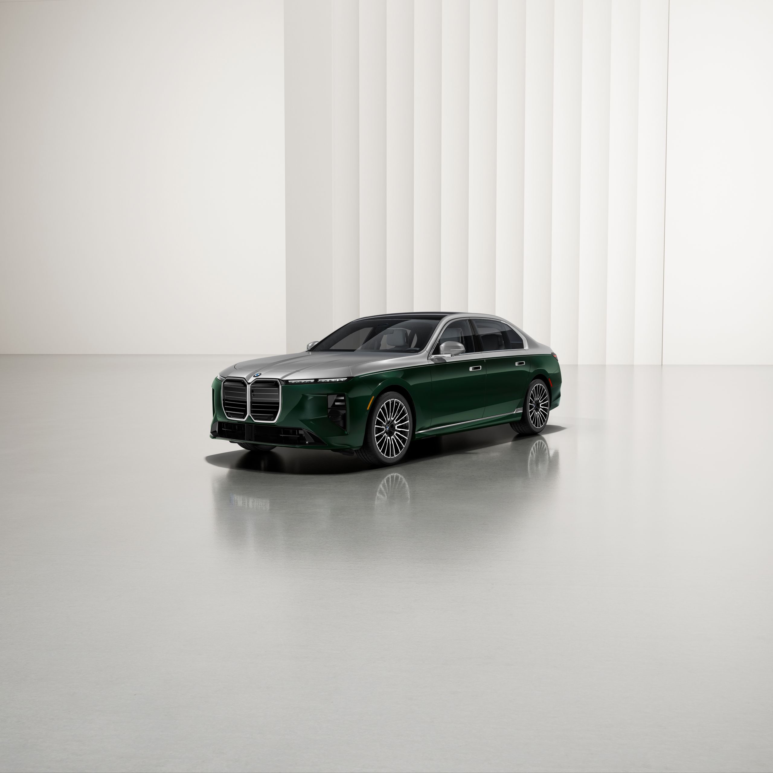 A BMW with two-tone paintwork at an angle on a reflective surface, with a modern background.
