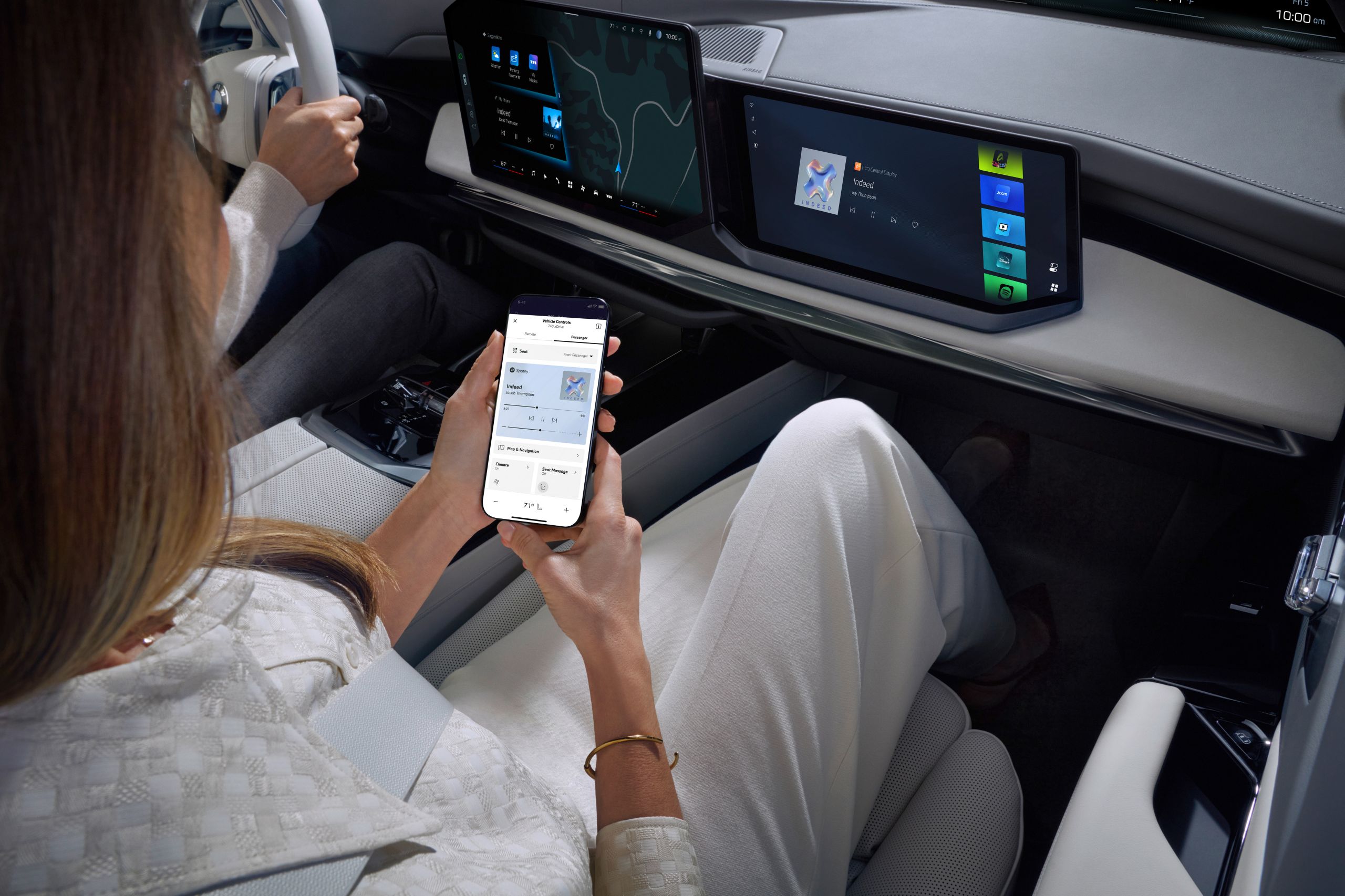 Person in the passenger seat operates a smartphone with the My BMW App.