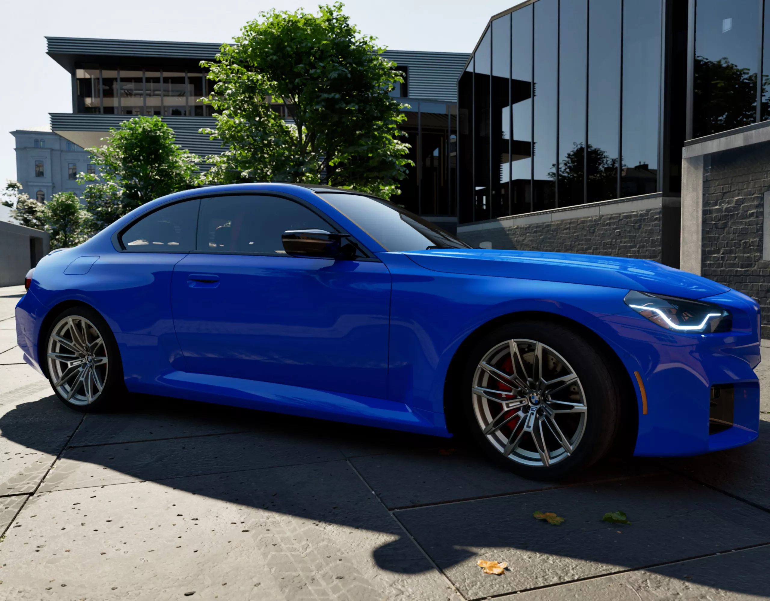 The M2 parked outside a modern building with a bold shadow cast on the ground.