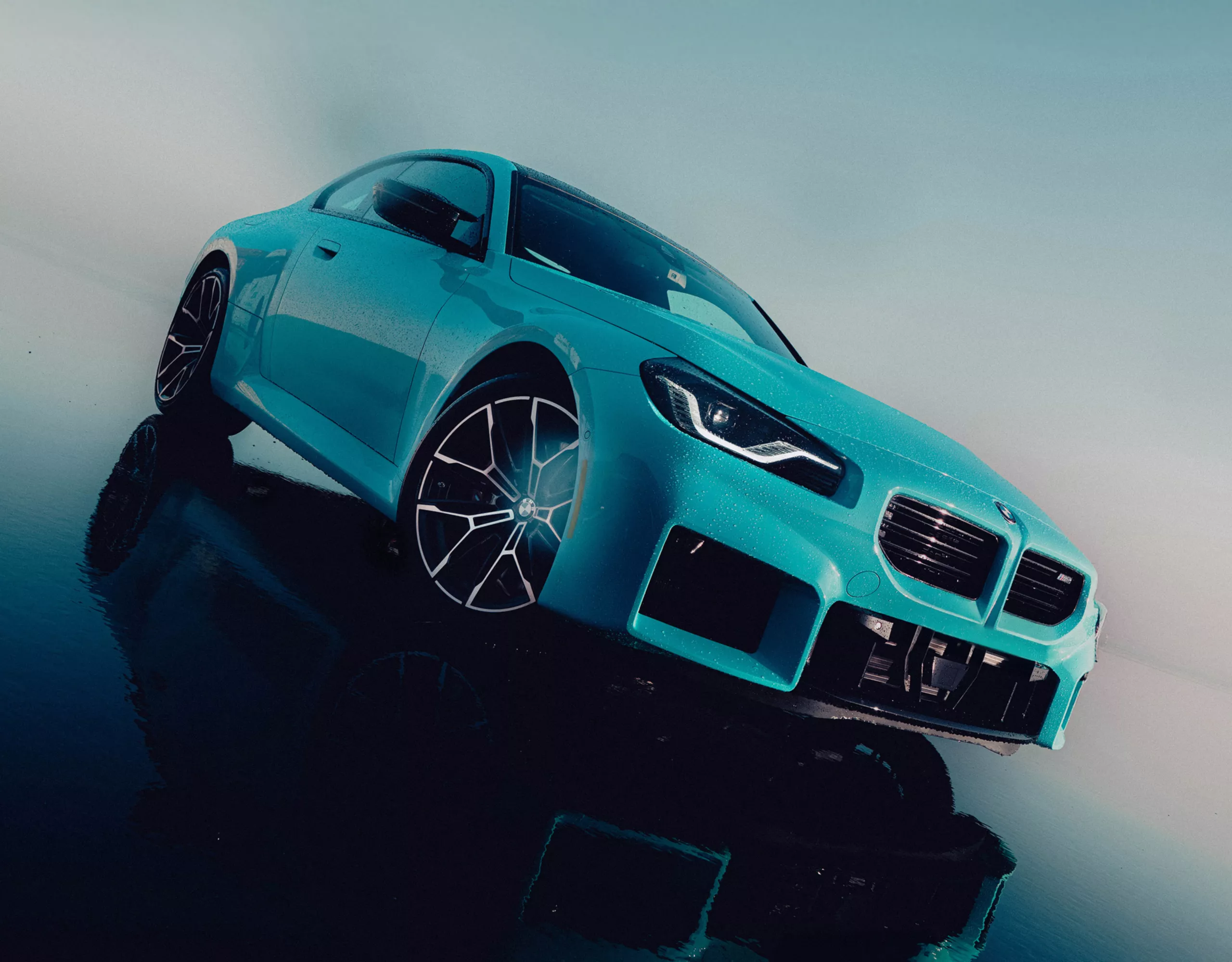 The M2 with M xDrive at a dramatic angle on a shining floor.