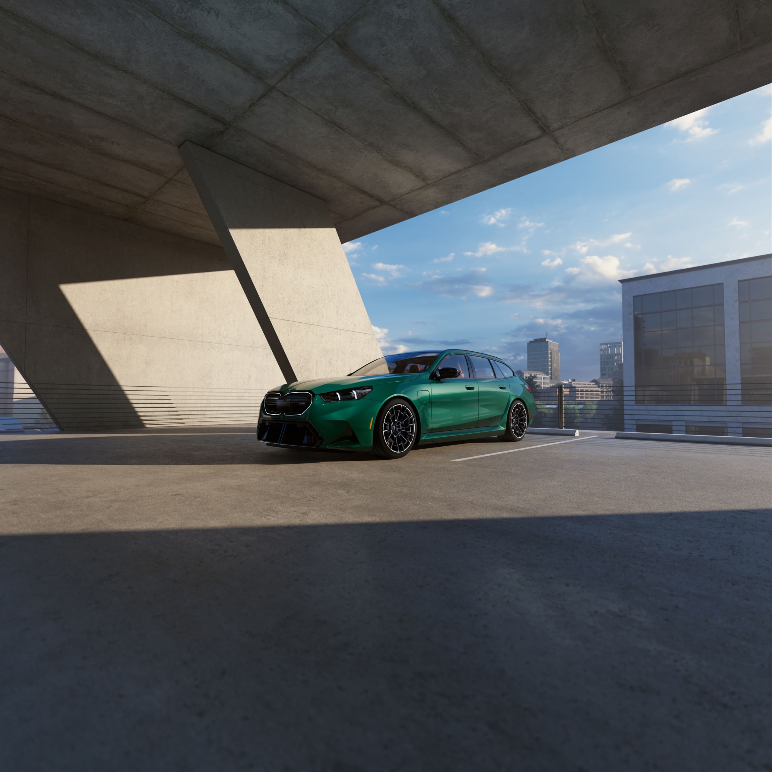 The BMW M5 Touring parked next to a cement structure.