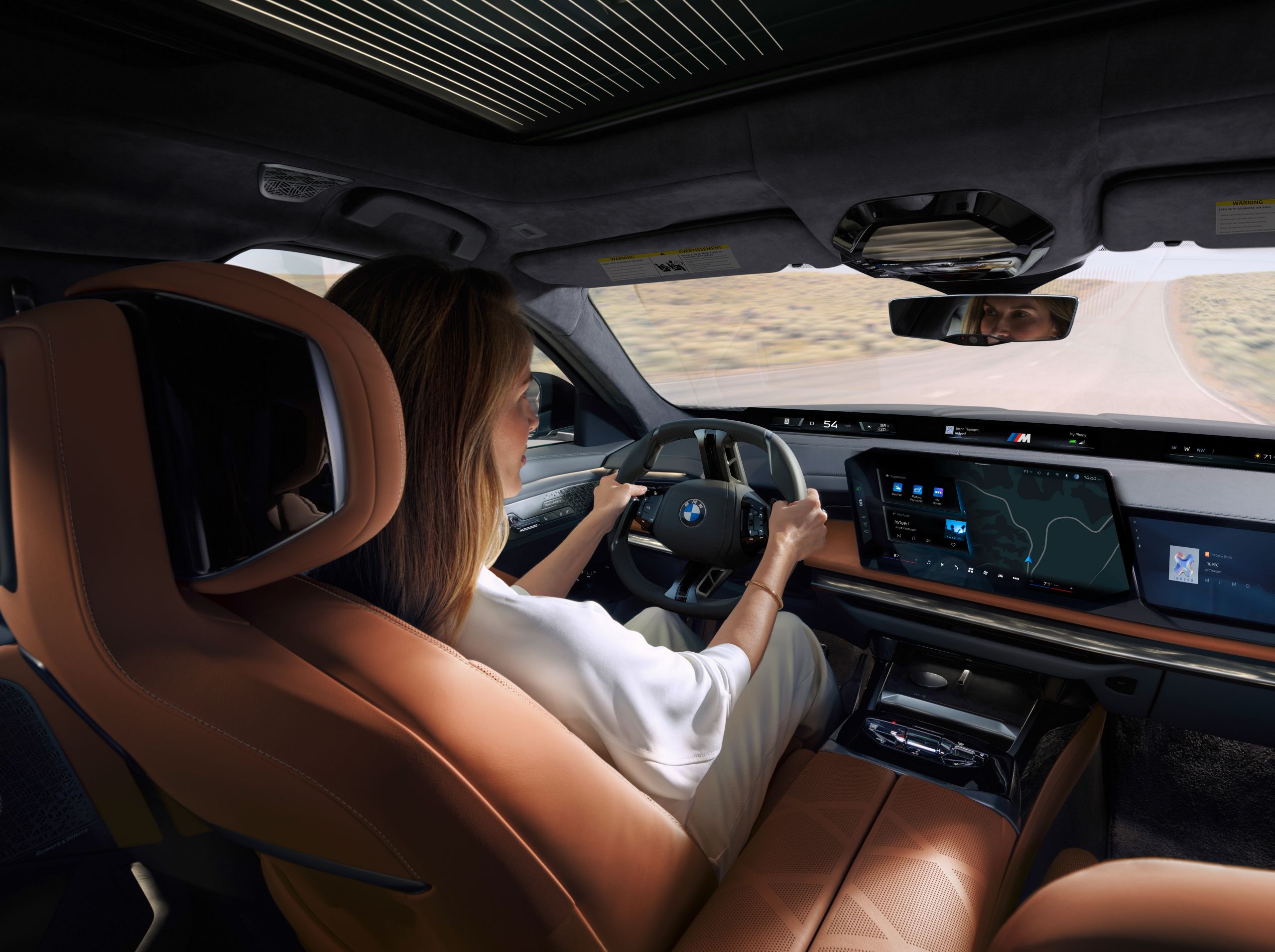 View from the rear seat bench to the driver, the steering wheel and the central information display.