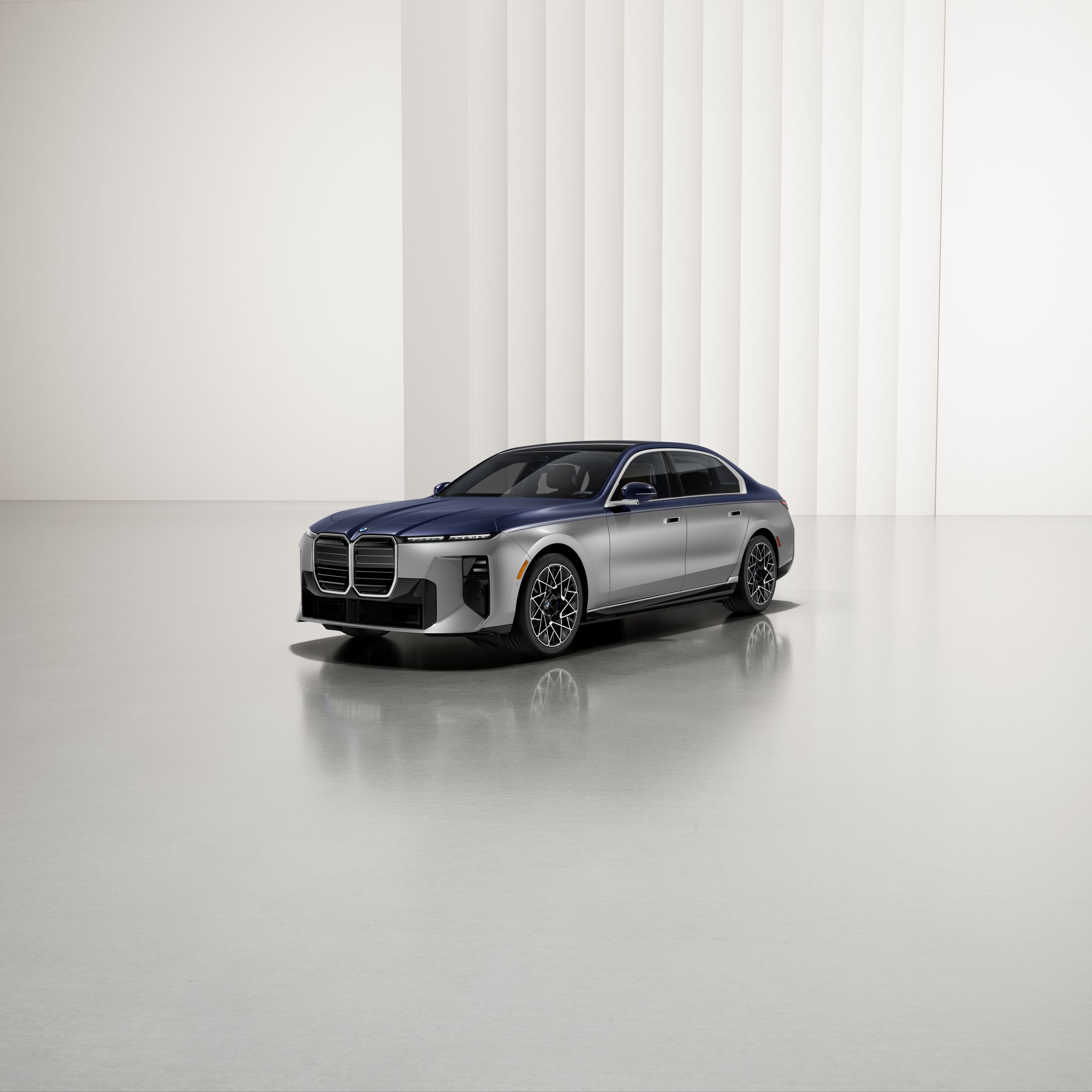 A BMW with two-tone paintwork at an angle on a reflective surface, with a modern background.