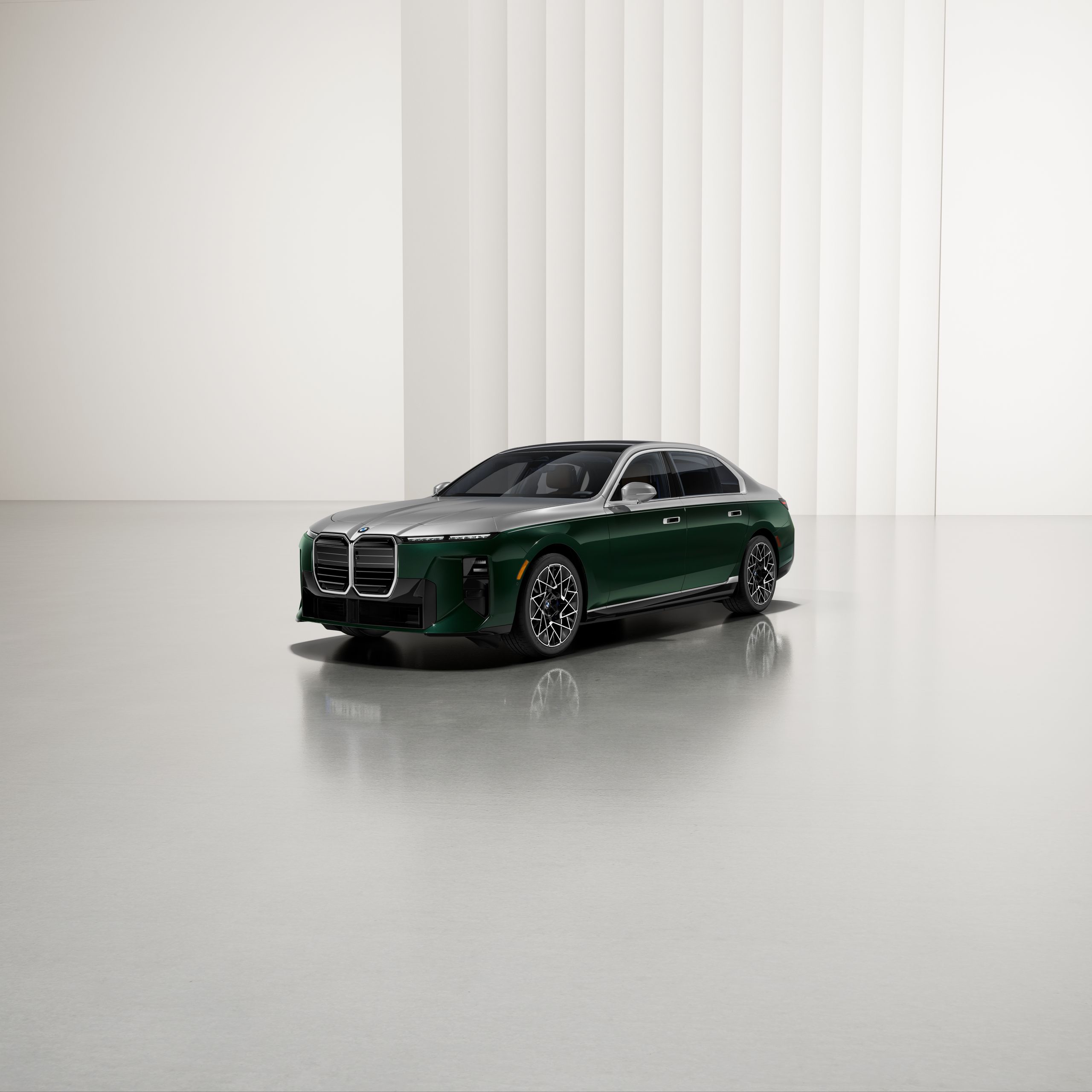 A BMW with two-tone paintwork at an angle on a reflective surface, with a modern background.